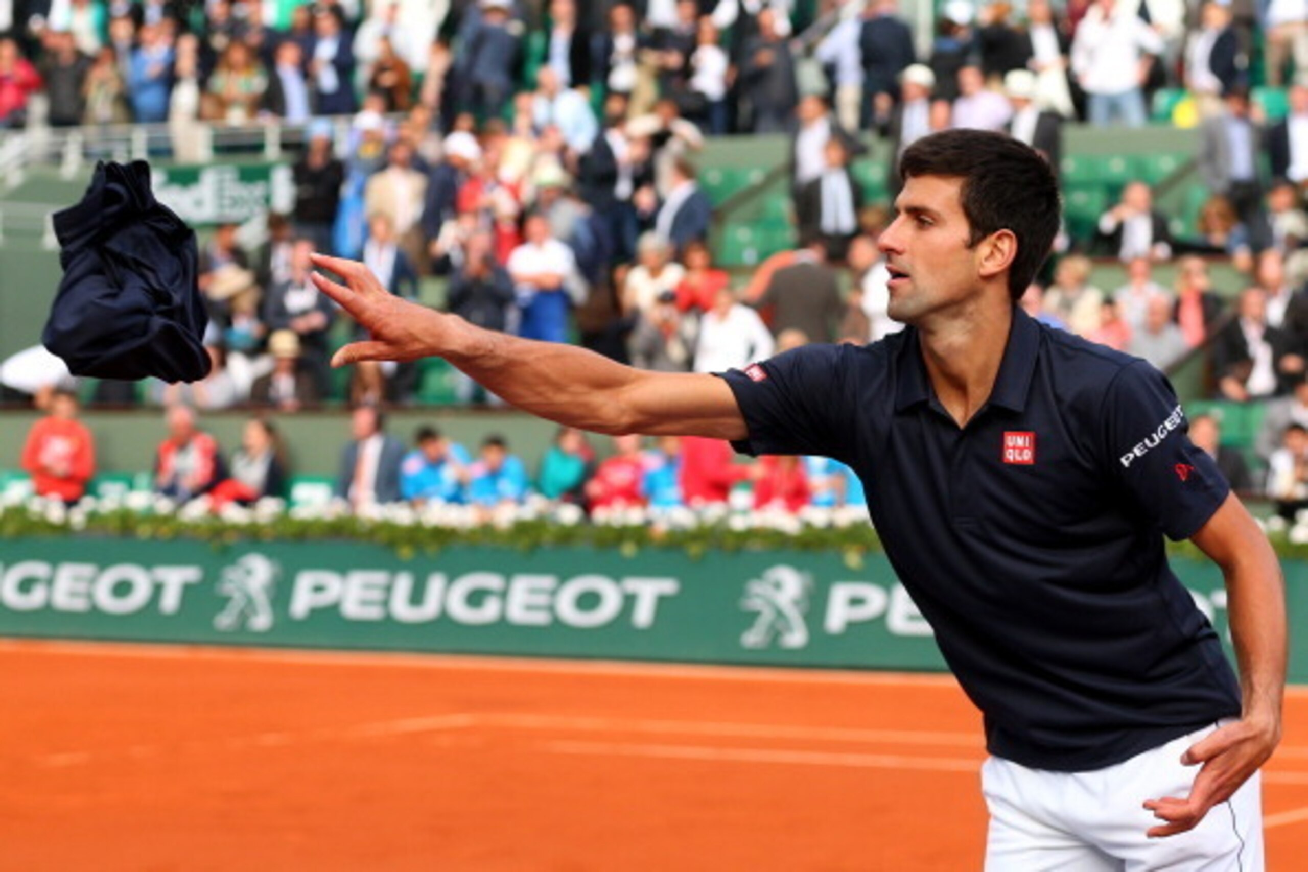 PARIS, FRANCE - JUNE 03:  Novak Djokovic of Serbia throws a shirt into the crowd as he celebrates victory in his men's singles match against Milos Raonic of Canada on day ten of the French Open at Roland Garros on June 3, 2014 in Paris, France.  (Photo by