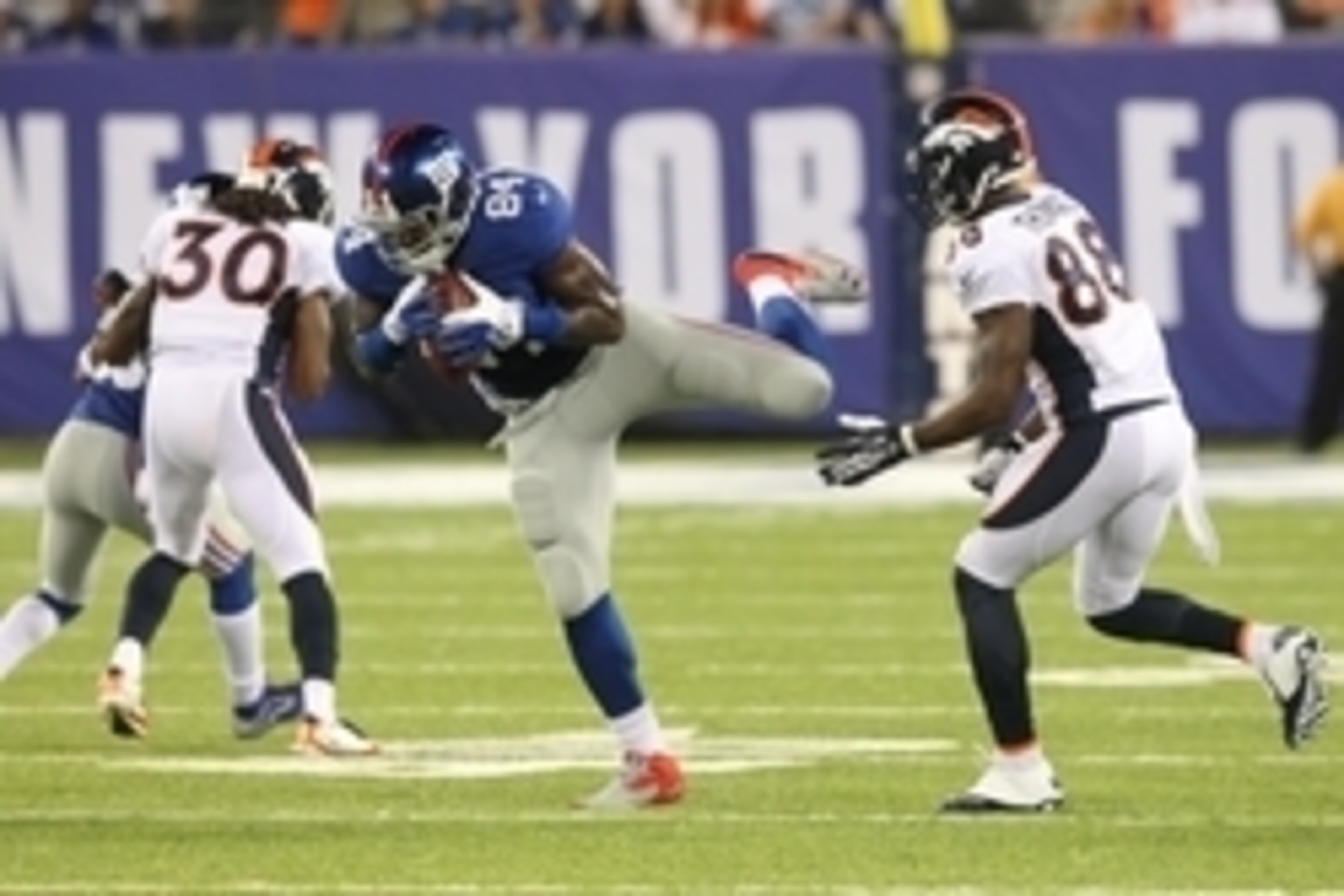 Sep 15, 2013; East Rutherford, NJ, USA; New York Giants tight end Larry Donnell (84) hauls in an on-sides kick in front of Denver Broncos wide receiver Demaryius Thomas (88) during the fourth quarter of a game at MetLife Stadium. The play was ruled illega