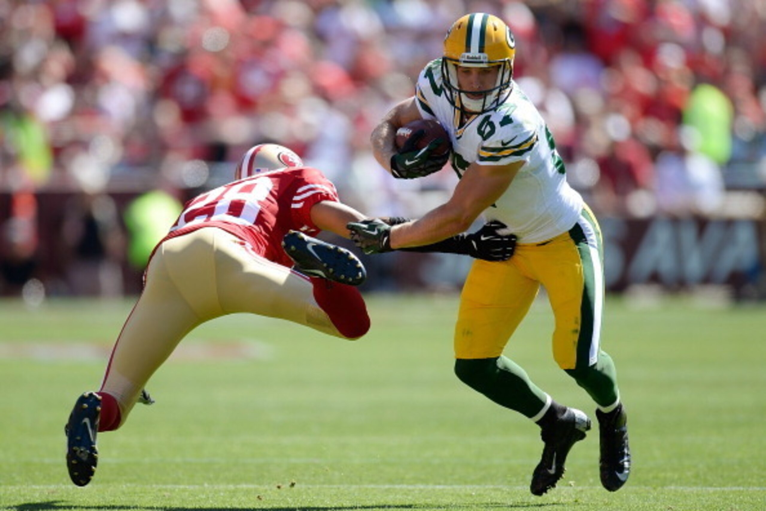 SAN FRANCISCO, CA - SEPTEMBER 08:  Jordy Nelson #87 of the Green Bay Packers breaks the tackle of Nnamdi Asomugha #28 of the San Francisco 49ers and goes fifteen yards on a pass play during the second quarter at Candlestick Park on September 8, 2013 in Sa