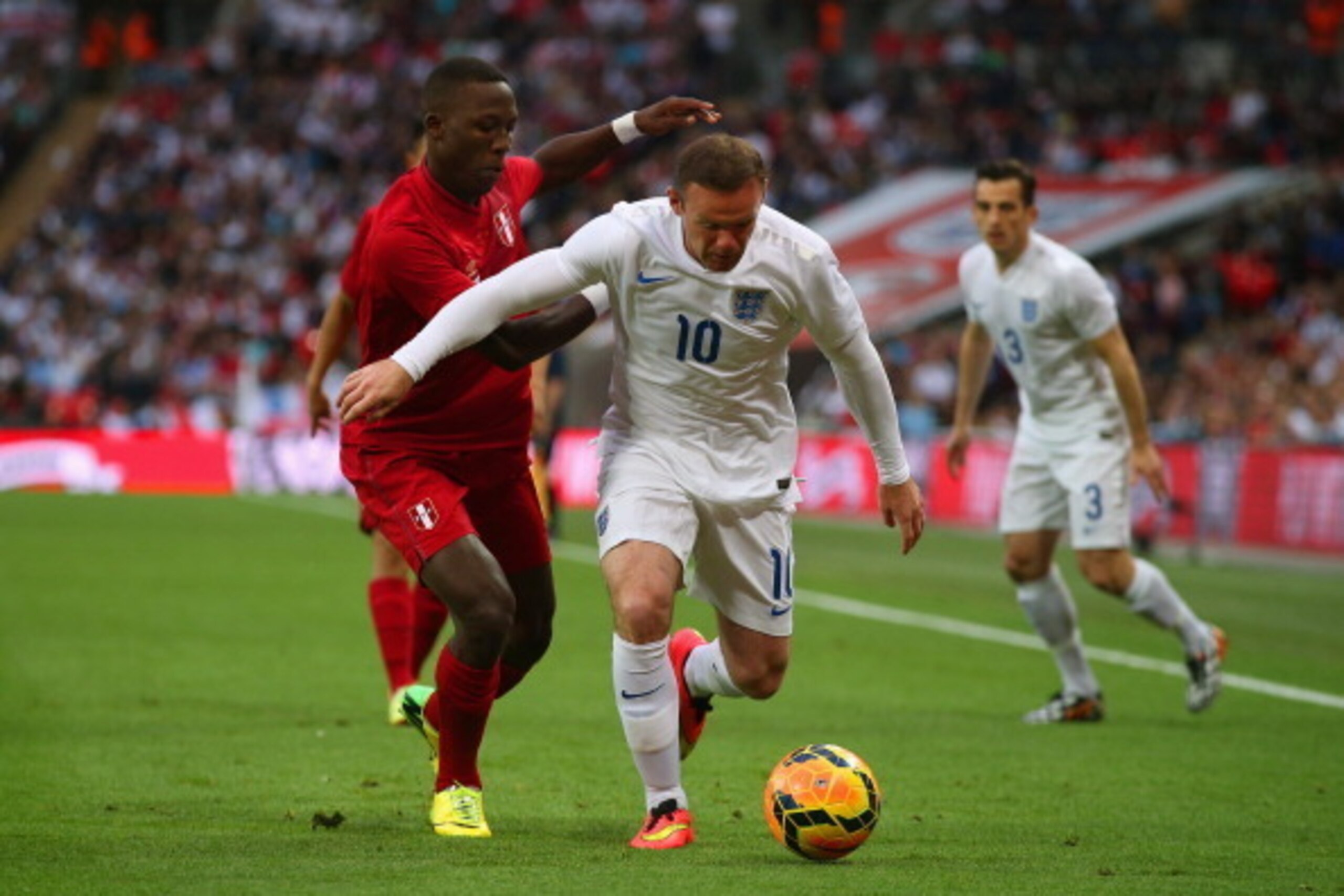 LONDON, ENGLAND - MAY 30:  Wayne Rooney of England is marshalled by Luis Advincula of Peru during the international friendly match between England and Peru at Wembley Stadium on May 30, 2014 in London, England.  (Photo by Clive Rose/Getty Images)