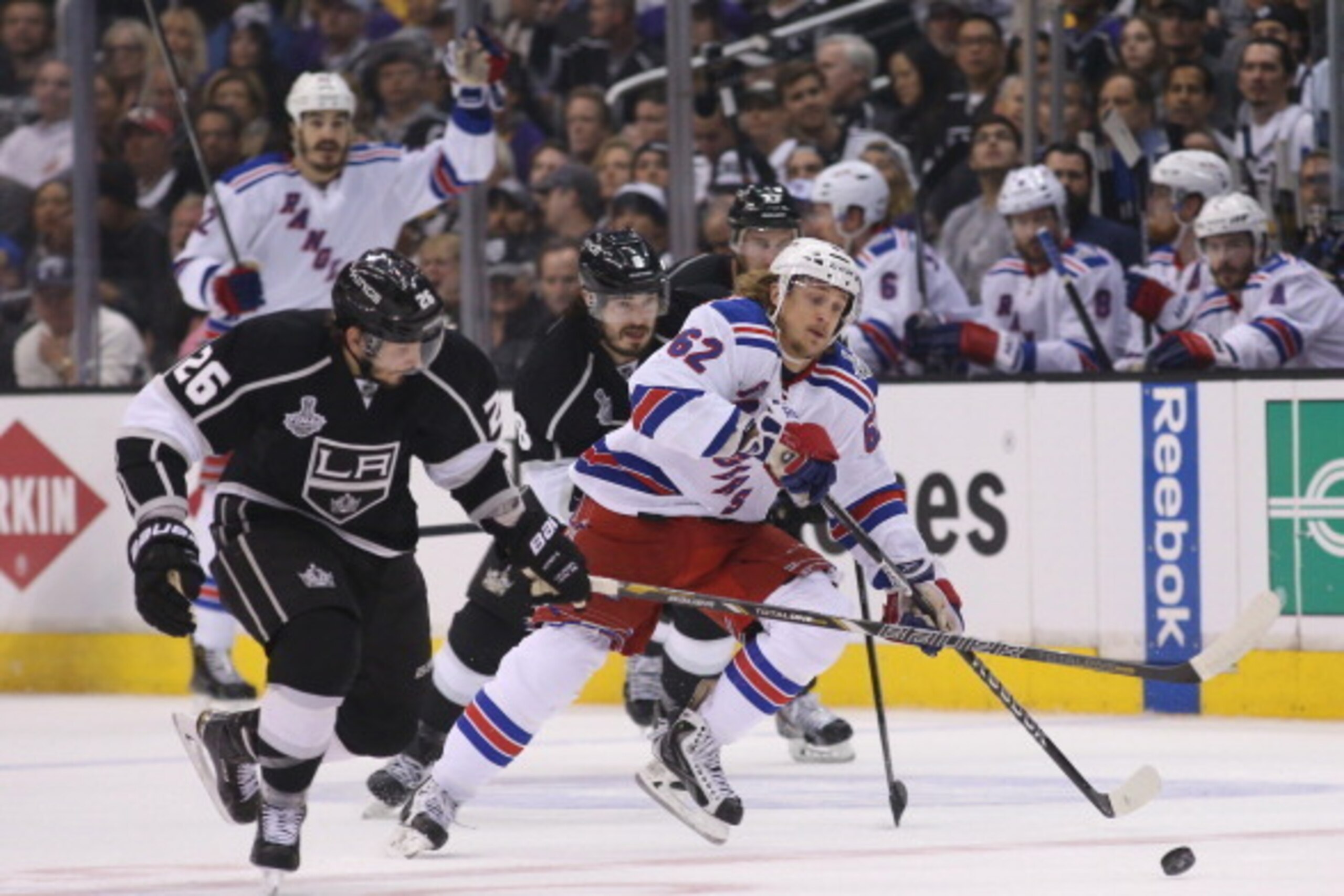 LOS ANGELES, CA - JUNE 04:  Carl Hagelin #62 of the New York Rangers with the puck against Slava Voynov #26 of the Los Angeles Kings in the first period during Game One of the 2014 NHL Stanley Cup Final at the Staples Center on June 4, 2014 in Los Angeles