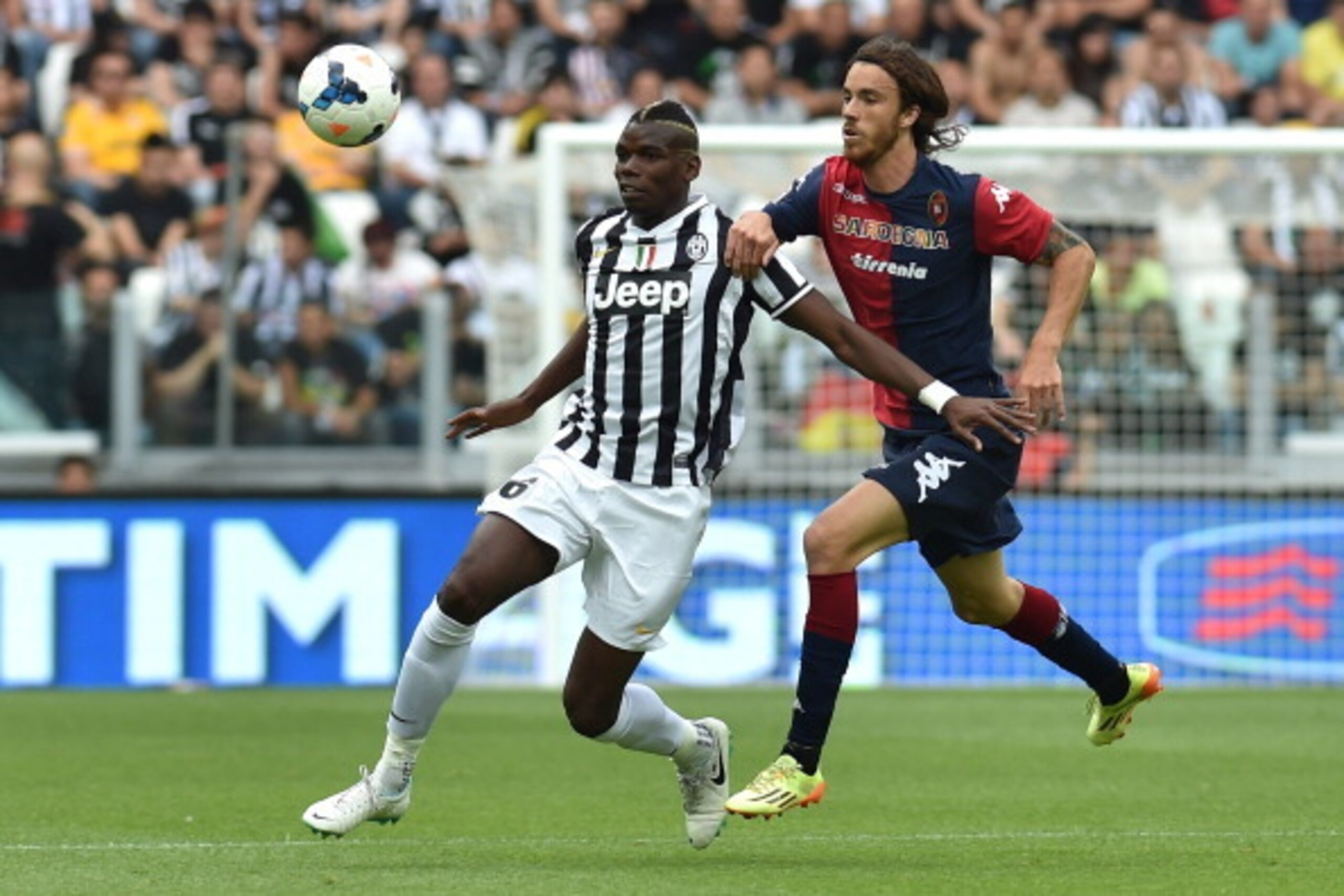 TURIN, ITALY - MAY 18:  Paul Pogba (L) of Juventus is challenged by Andrea Tabanelli of Cagliari Calcio during the Serie A match between Juventus and Cagliari Calcio at Juventus Arena on May 18, 2014 in Turin, Italy.  (Photo by Valerio Pennicino/Getty Ima