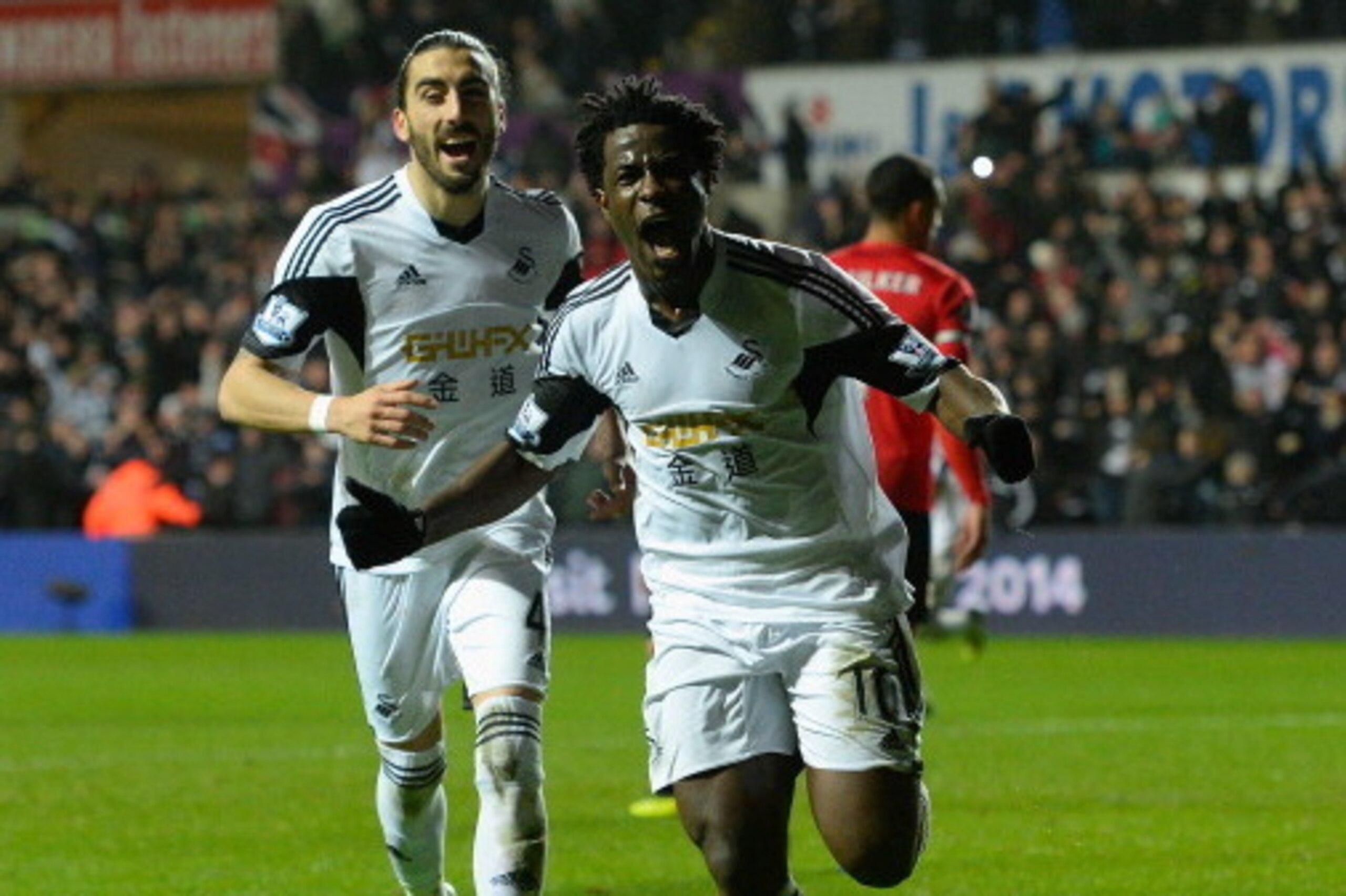 SWANSEA, WALES - FEBRUARY 08:  Swansea striker Wilfried Bony (r) celebrates with Chico Flores after scoring the third goal during the Barclays Premier League match between Swansea City and Cardiff City at Liberty Stadium on February 8, 2014 in Swansea, Wa