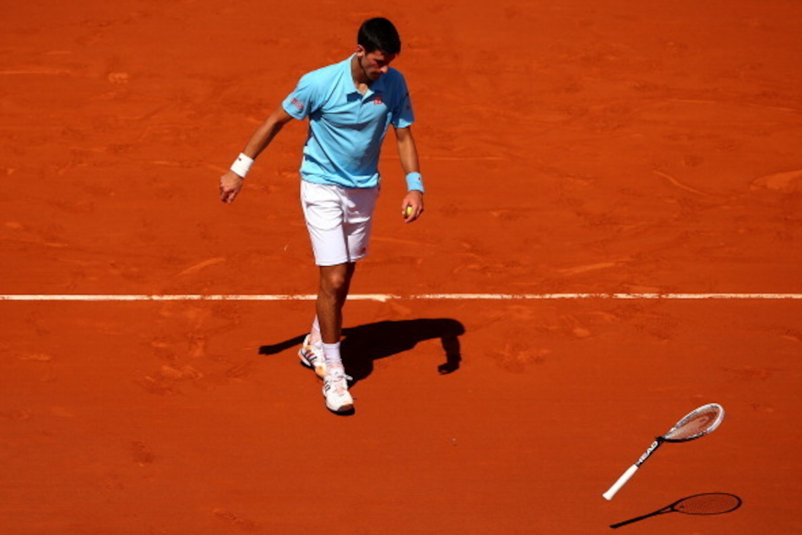 PARIS, FRANCE - JUNE 06:  Novak Djokovic of Serbia smashes his racquet during his men's singles semi-final match against Ernests Gulbis of Latvia on day thirteen of the French Open at Roland Garros on June 6, 2014 in Paris, France.  (Photo by Clive Brunsk