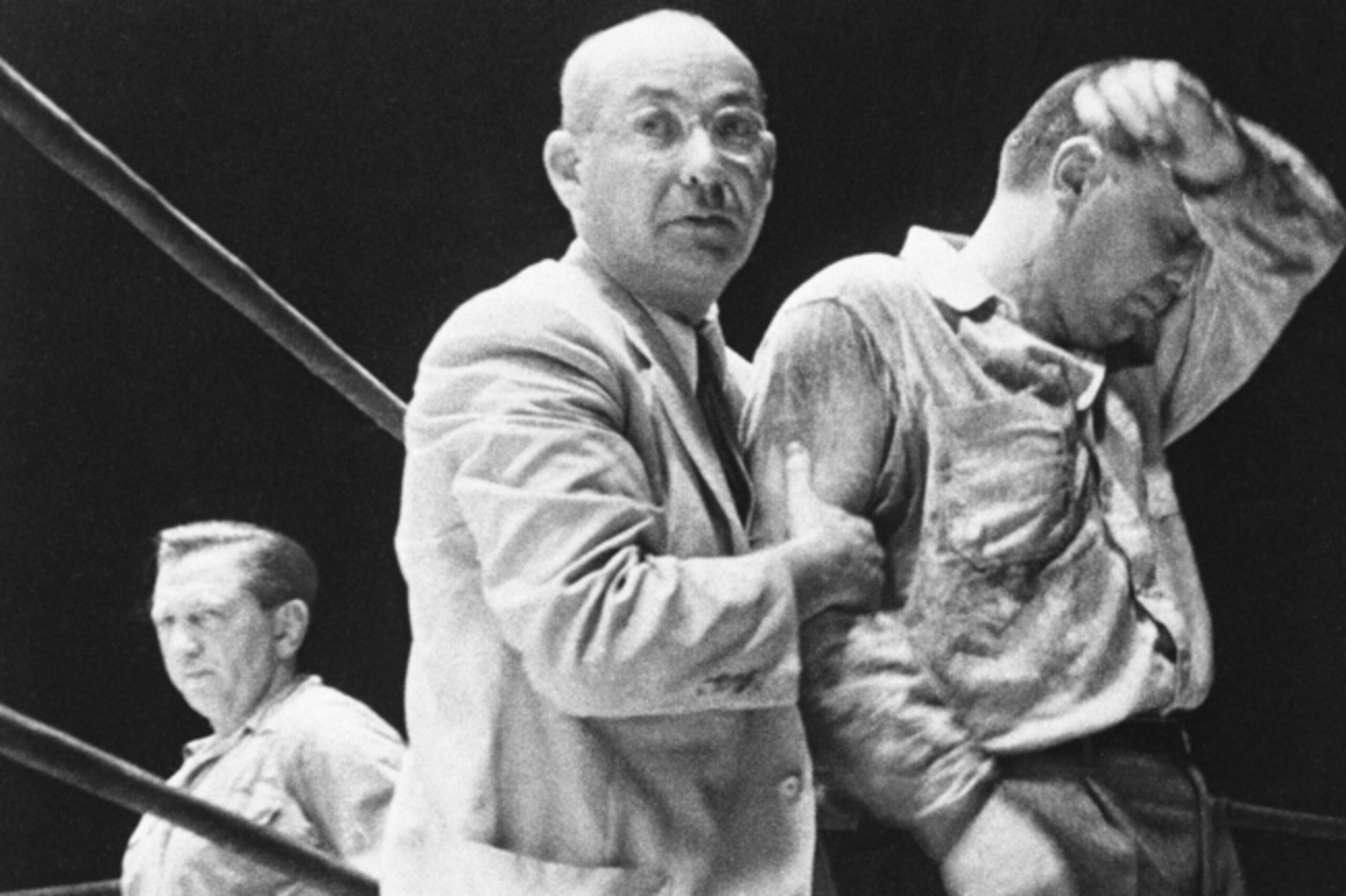 Unable to cope with the intense heat, ref Goldstein is helped out of the ring