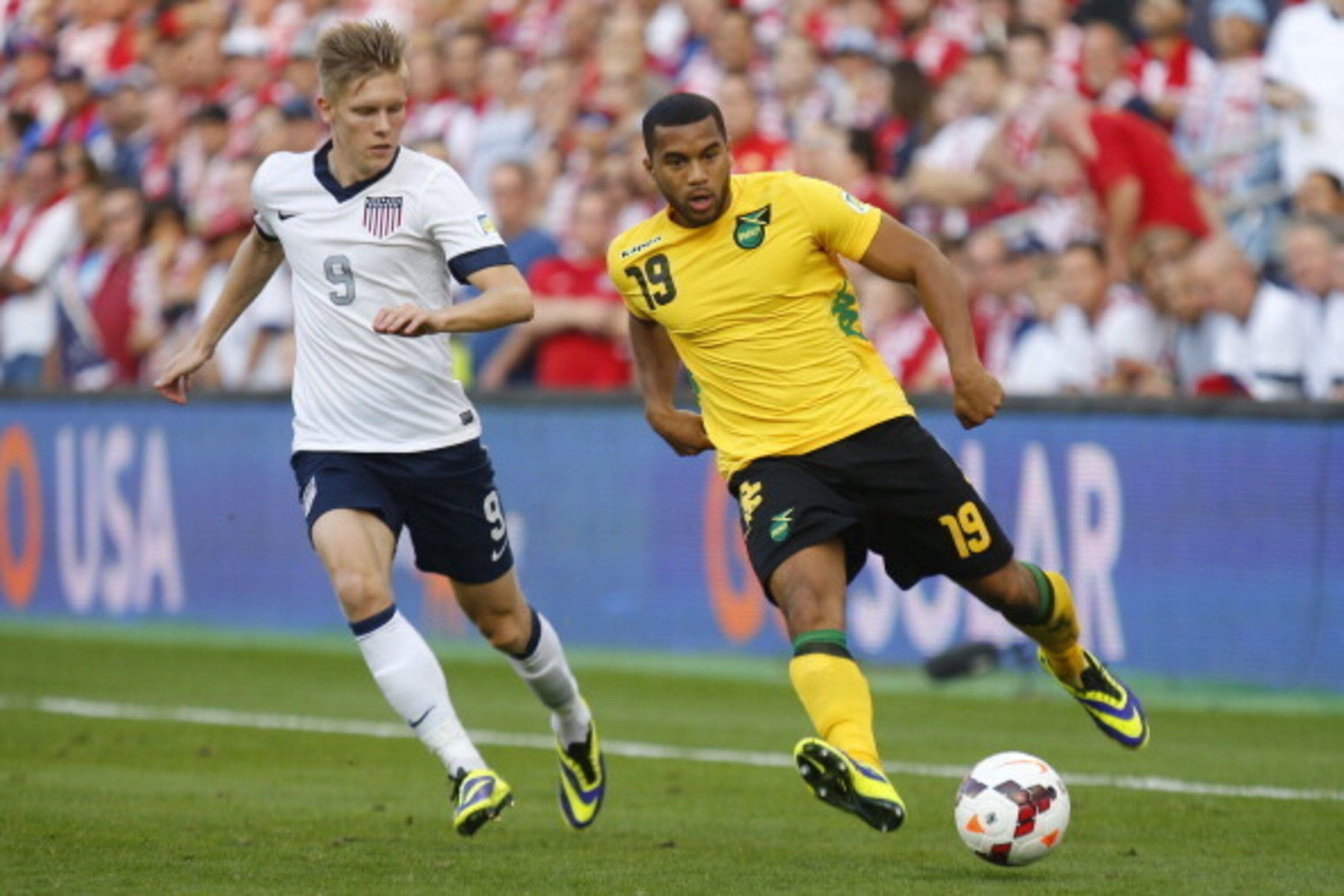 KANSAS CITY, KS - OCTOBER 11: Adrain Mariappa #19 of the Jamaica drives past Aron Johannsson #9 of the U.S. Men's National Soccer Team early in the first half at Sporting Park on October 11, 2013 in Kansas City, Kansas. (Photo by Kyle Rivas/Getty Images)