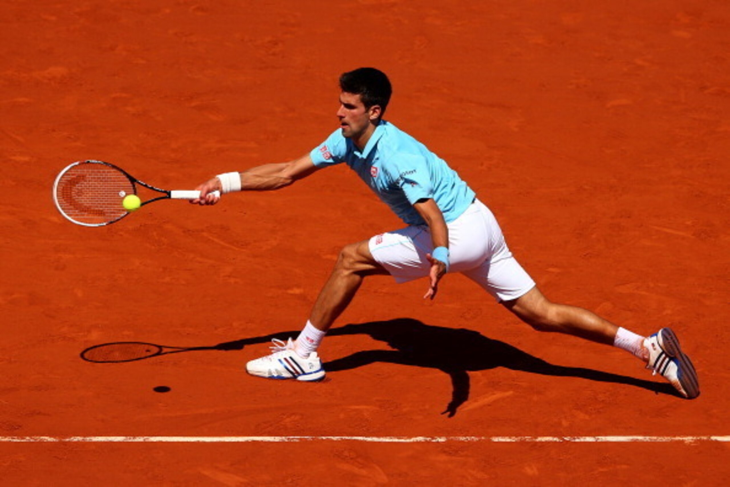 PARIS, FRANCE - JUNE 06:  Novak Djokovic of Serbia returns a shot during his men's singles semi-final match against Ernests Gulbis of Latvia on day thirteen of the French Open at Roland Garros on June 6, 2014 in Paris, France.  (Photo by Clive Brunskill/G