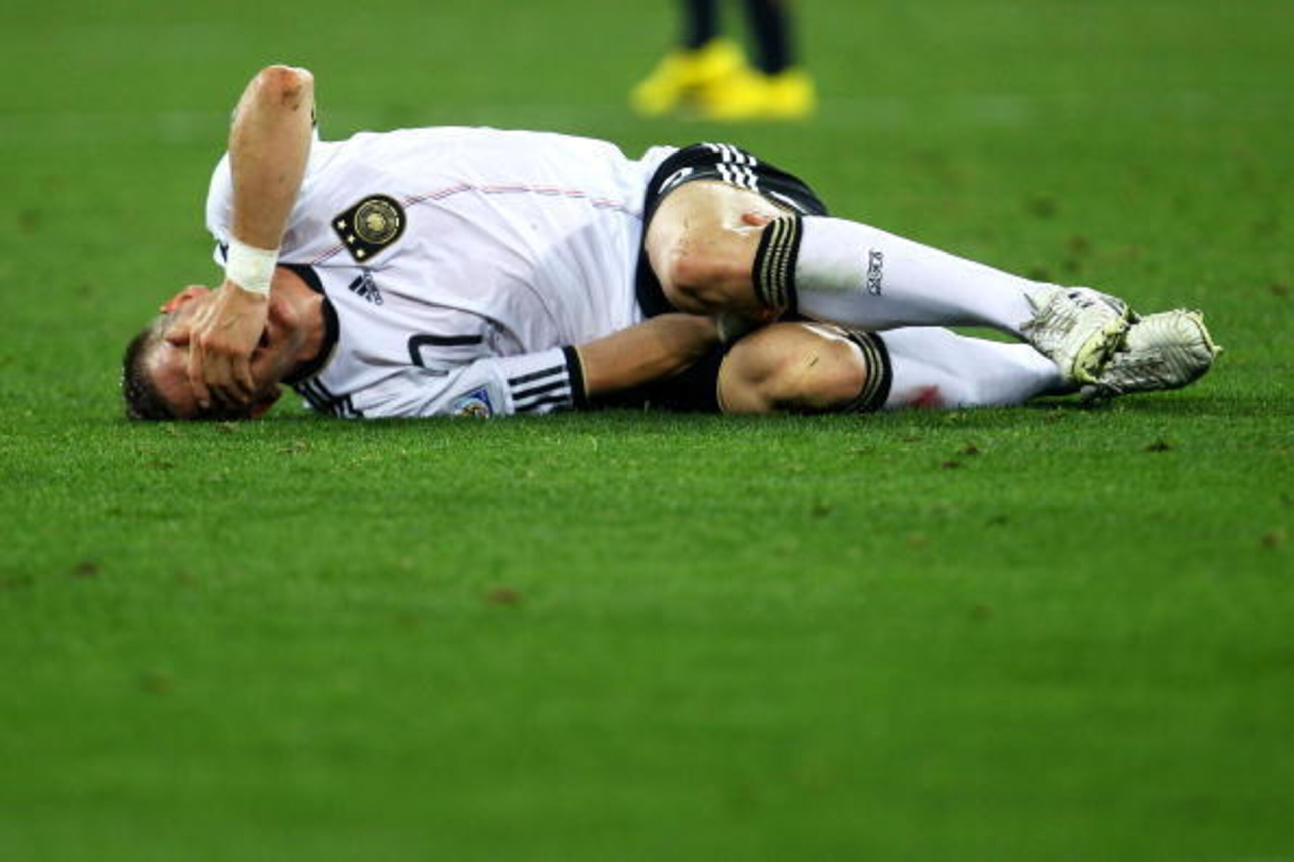 DURBAN, SOUTH AFRICA - JUNE 13:  Injured Bastian Schweinsteiger lies on the ground during the 2010 FIFA World Cup South Africa Group D match between Germany and Australia at Durban Stadium on June 13, 2010 in Durban, South Africa.  (Photo by Lars Baron/Ge