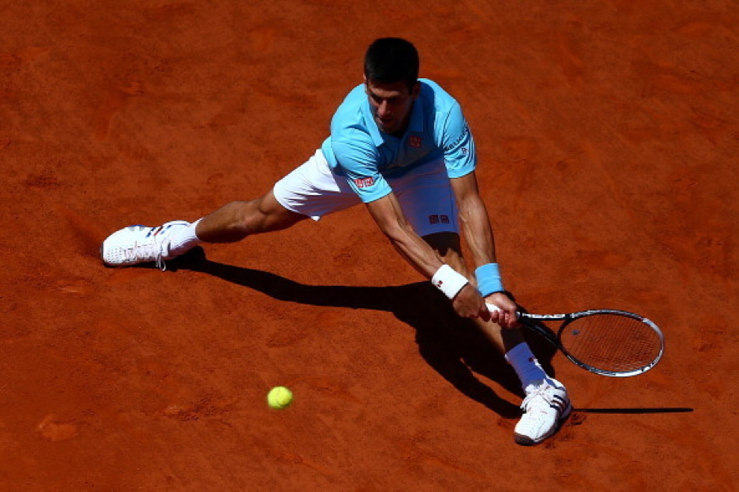 PARIS, FRANCE - JUNE 06:  Novak Djokovic of Serbia returns a shot during his men's singles semi-final match against Ernests Gulbis of Latvia on day thirteen of the French Open at Roland Garros on June 6, 2014 in Paris, France.  (Photo by Dan Istitene/Gett