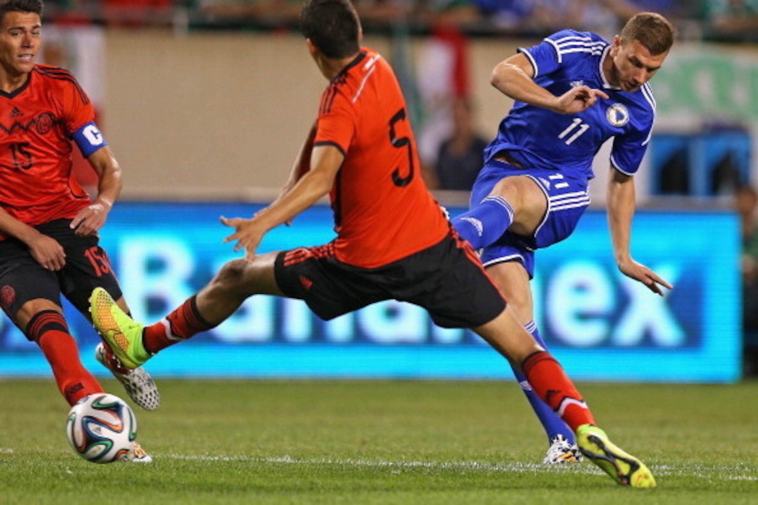 CHICAGO, IL - JUNE 03: Edin Dzeko #11 of Bosnia & Herzegovina shoots the ball between Hector Moreno #15 and Diego Reyes #5 of Mexico during an international friendly match at Soldier Field on June 3, 2014 in Chicago, Illinois. (Photo by Jonathan Daniel/Ge