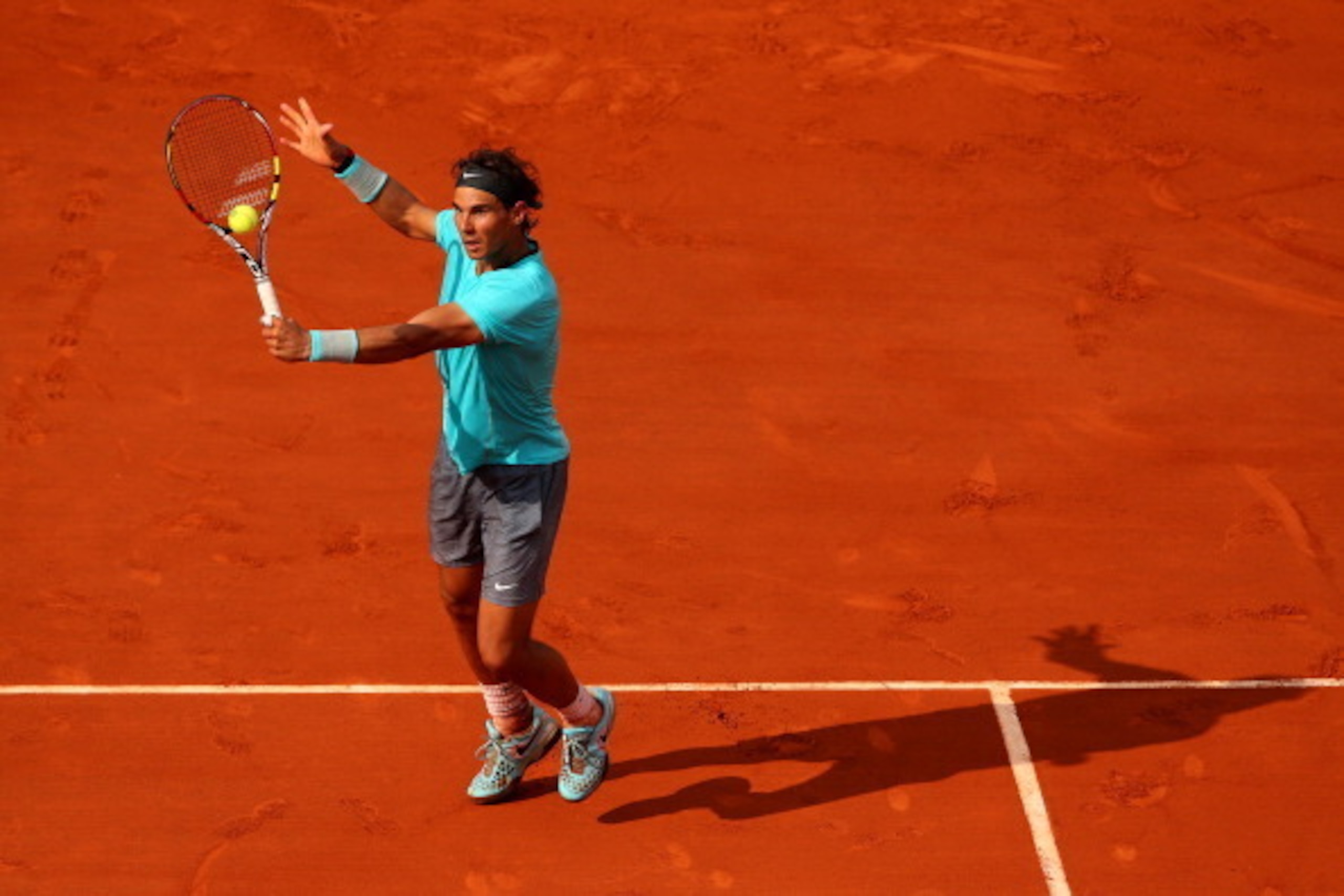 PARIS, FRANCE - JUNE 08:  Rafael Nadal of Spain returns a shot during his men's singles final match against Novak Djokovic of Serbia on day fifteen of the French Open at Roland Garros on June 8, 2014 in Paris, France.  (Photo by Clive Brunskill/Getty Imag