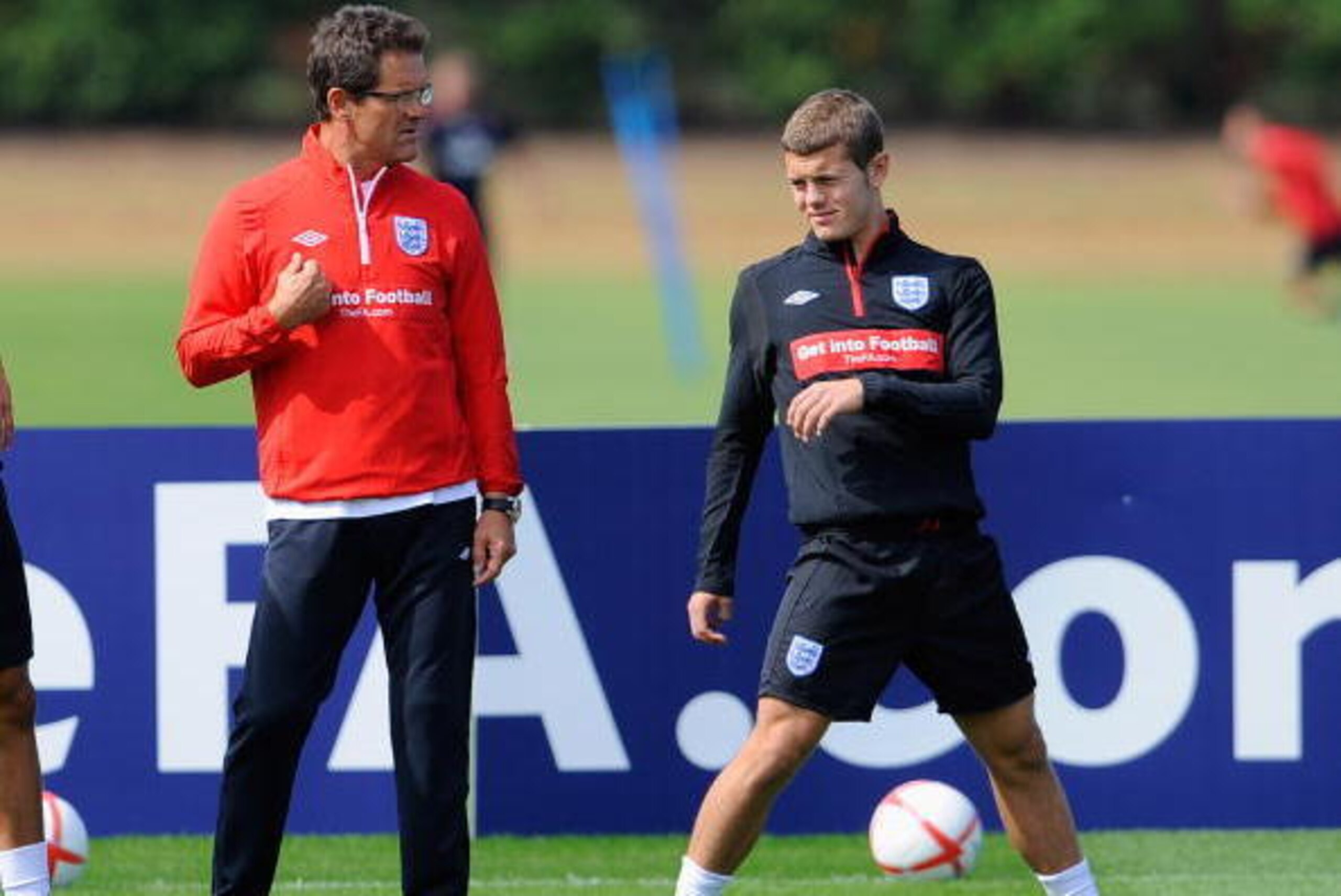 ST ALBANS, ENGLAND - AUGUST 09:  England manger Fabio Capello talks to Jack Wilshere during the England training session at London Colney on August 9, 2010 in St Albans, England.  (Photo by Michael Regan/Getty Images)