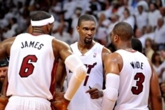 May 8, 2014; Miami, FL, USA; Miami Heat forward LeBron James (left) talks with center Chris Bosh (center) and  guard Dwyane Wade (right) during the second half in game two of the second round of the 2014 NBA Playoffs against the Brooklyn Nets at American 