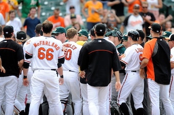 BALTIMORE, MD - JUNE 08:  Players run onto the field after Manny Machado of the Baltimore Orioles threw a bat during the eighth inning against the Oakland Athletics at Oriole Park at Camden Yards on June 8, 2014 in Baltimore, Maryland. Machado was ejected