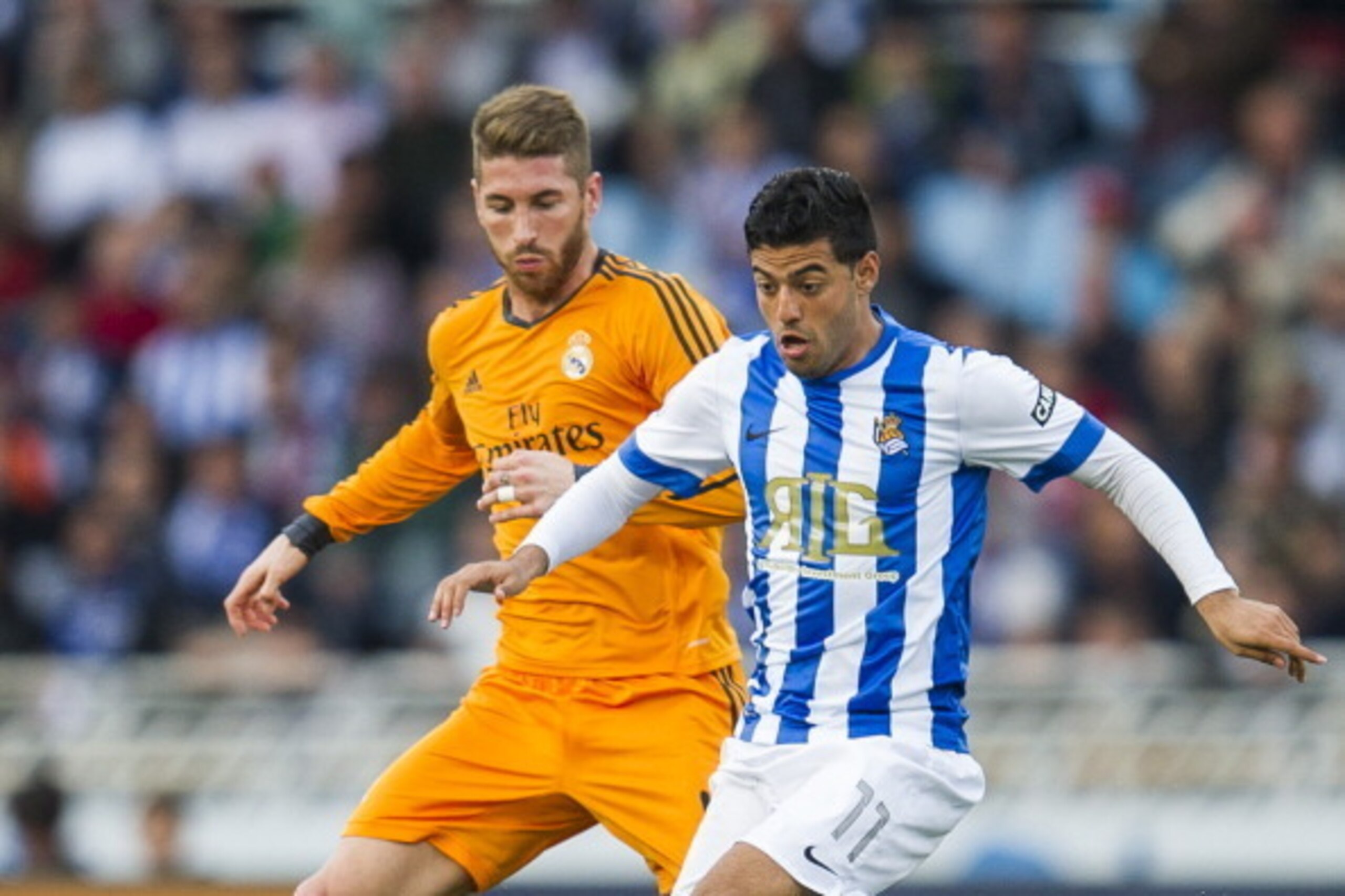 SAN SEBASTIAN, SPAIN - APRIL 05: Sergio Ramos of Real Madrid CF duels for the ball with Carlos Vela of Real Sociedad during the La Liga match between Real Sociedad and Real Madrid CF at Estadio Anoeta on April 5, 2014 in San Sebastian, Spain.  (Photo by J