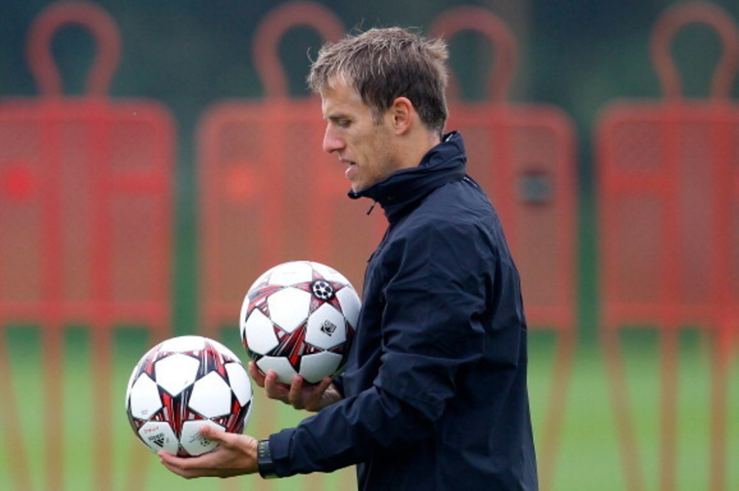 MANCHESTER, ENGLAND - OCTOBER 01: First team coach Phil Neville of Manchester United carries footballs during a training session ahead of their Champions League Group A match against Shakhtar Donetsk at their Carrington Training Complex on October 01, 201