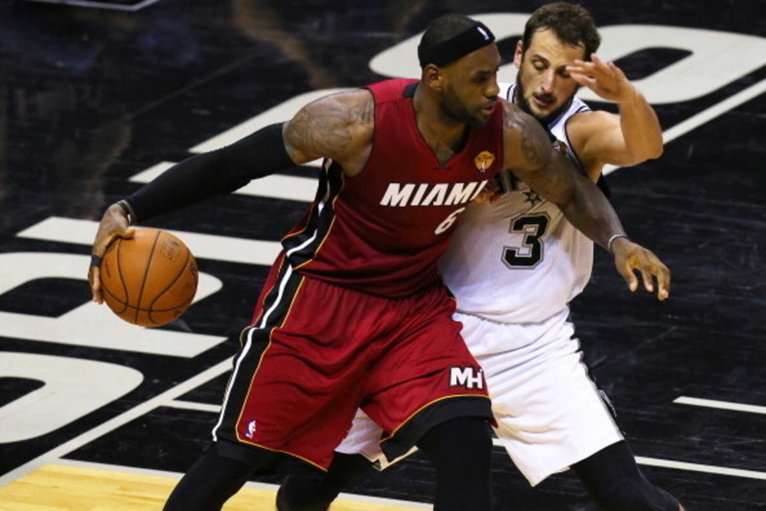 SAN ANTONIO, TX - JUNE 5: LeBron James #6 of the Miami Heat holds the ball away from Marco Belinelli #3 of the San Antonio Spurs in Game One of the 2014 NBA Finals at the AT&T Center on June 5, 2014 in San Antonio, Texas. NOTE TO USER: User expressly ackn
