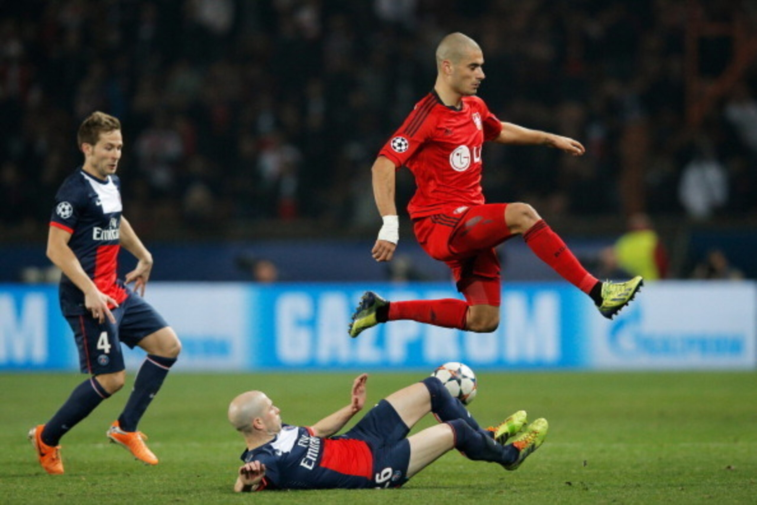 PARIS, FRANCE - MARCH 12:  Eren Derdiyok of Bayer Leverkusen jumps a tackle from Christophe Jallet of Paris Saint-Germain during the UEFA Champions League Round of 16 second leg match between Paris Saint-Germain FC and Bayer Leverkusen at Parc des Princes