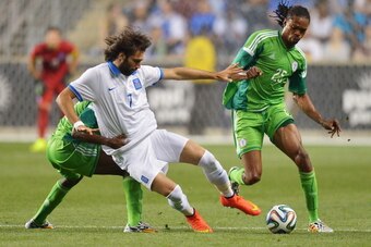 CHESTER, PA - JUNE 3:  Giorgos Samaras #7 of Greece gets pulled down by Kunle Odunlami #12 of Nigeria, as Odunlami's teammate Michael Uchebo #25 tries to gain control of the ball during an international friendly match at PPL Park on June 3, 2014 in Cheste