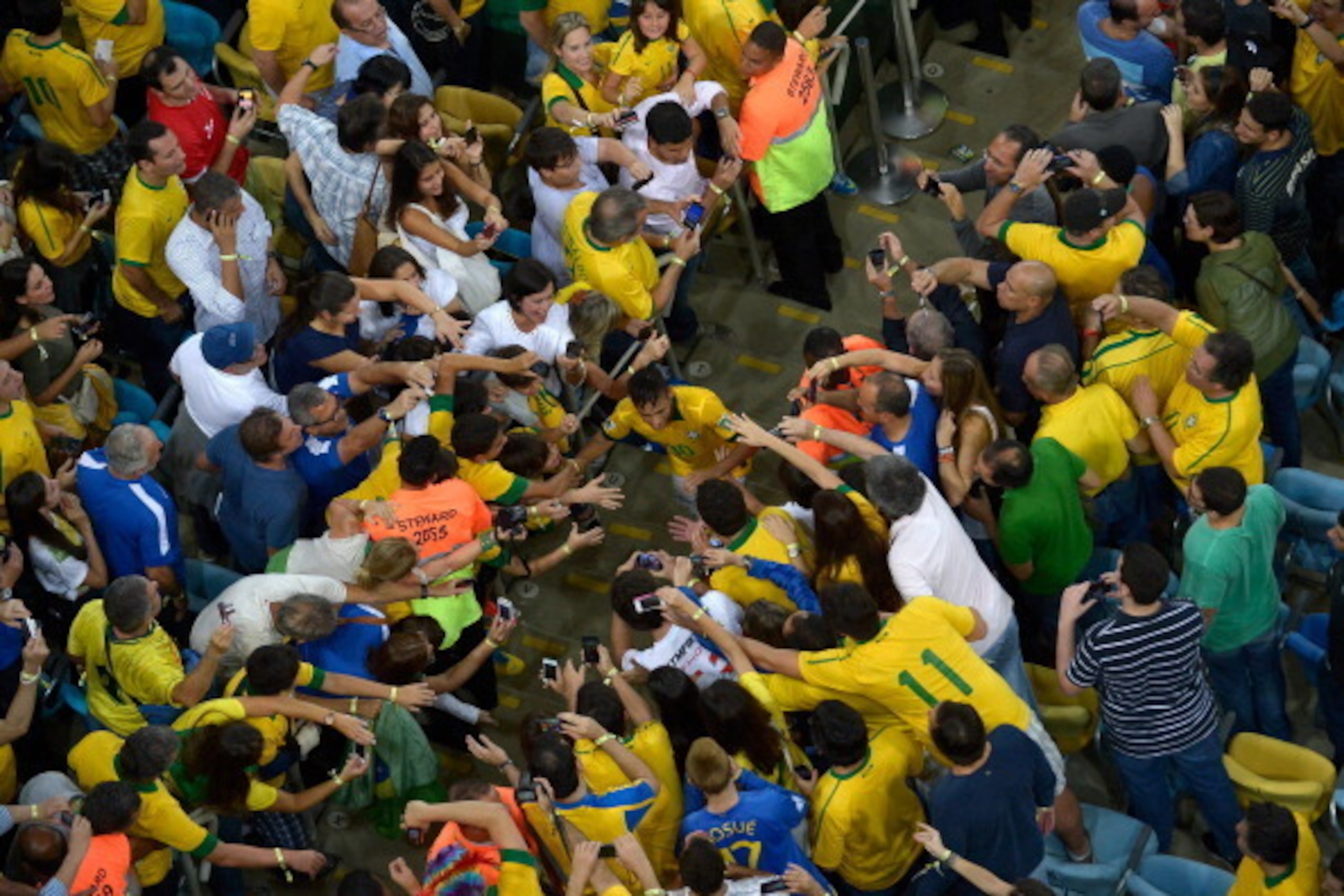 RIO DE JANEIRO, BRAZIL - JUNE 30:  (EDITORIAL USE ONLY) In this handout image provided by FIFA Neymar of Brazil is congratulated by fans at the end of the FIFA Confederations Cup Brazil 2013 Final match between Brazil and Spain at Maracana on June 30, 201