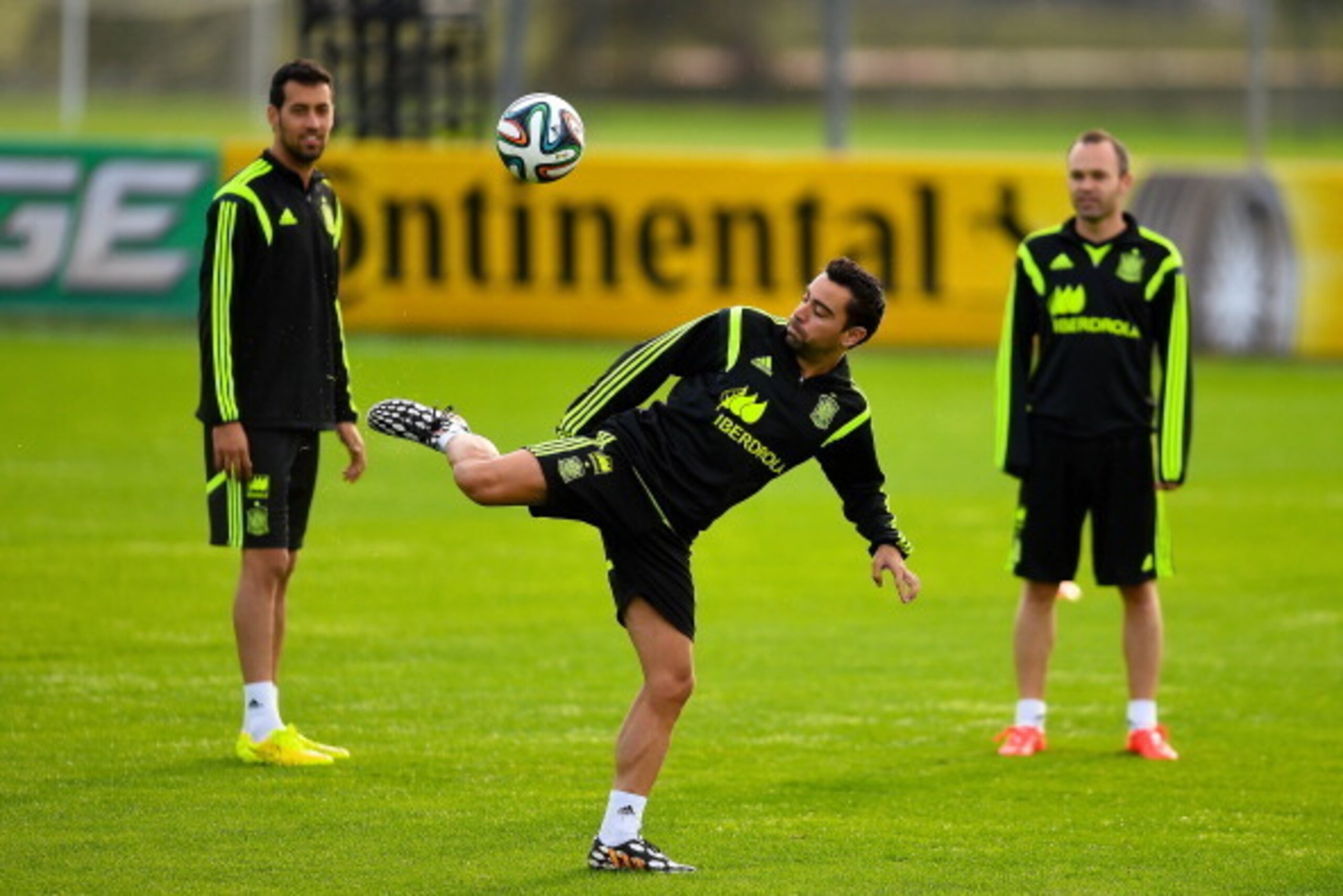 CURITIBA, BRAZIL - JUNE 09:  Xavi Hernandez (C) of Spain juggles the ball next to his teammates Sergi Busquets (L) and Andres Iniesta during a Spain training session at the Centro de Entrenamiento do Caju on June 9, 2014 in Curitiba, Brazil.  (Photo by Da