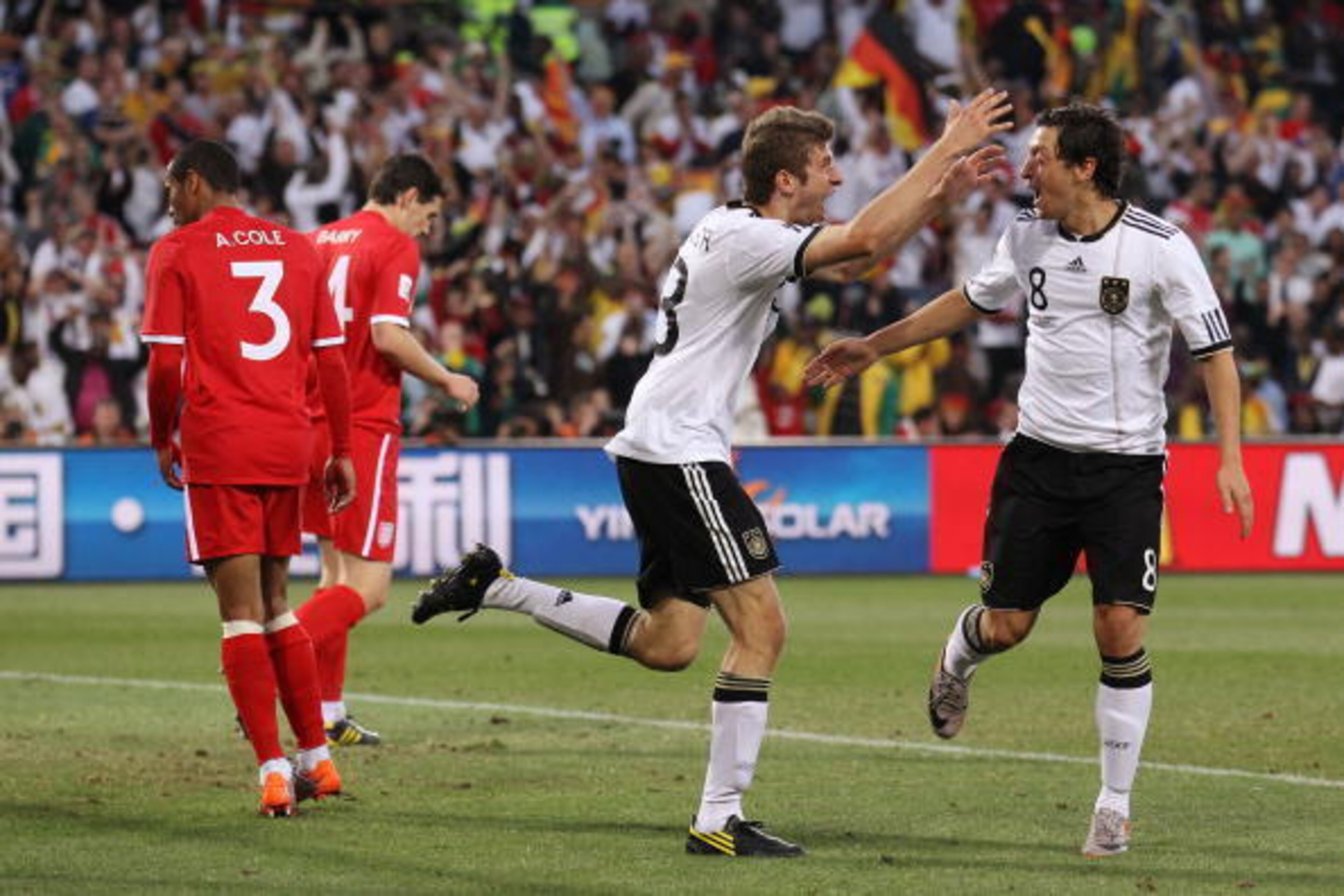 BLOEMFONTEIN, SOUTH AFRICA - JUNE 27:  Thomas Mueller of Germany celebrates scoring his teams fourth goal with team mate Mesut Oezil during the 2010 FIFA World Cup South Africa Round of Sixteen match between Germany and England at Free State Stadium on Ju