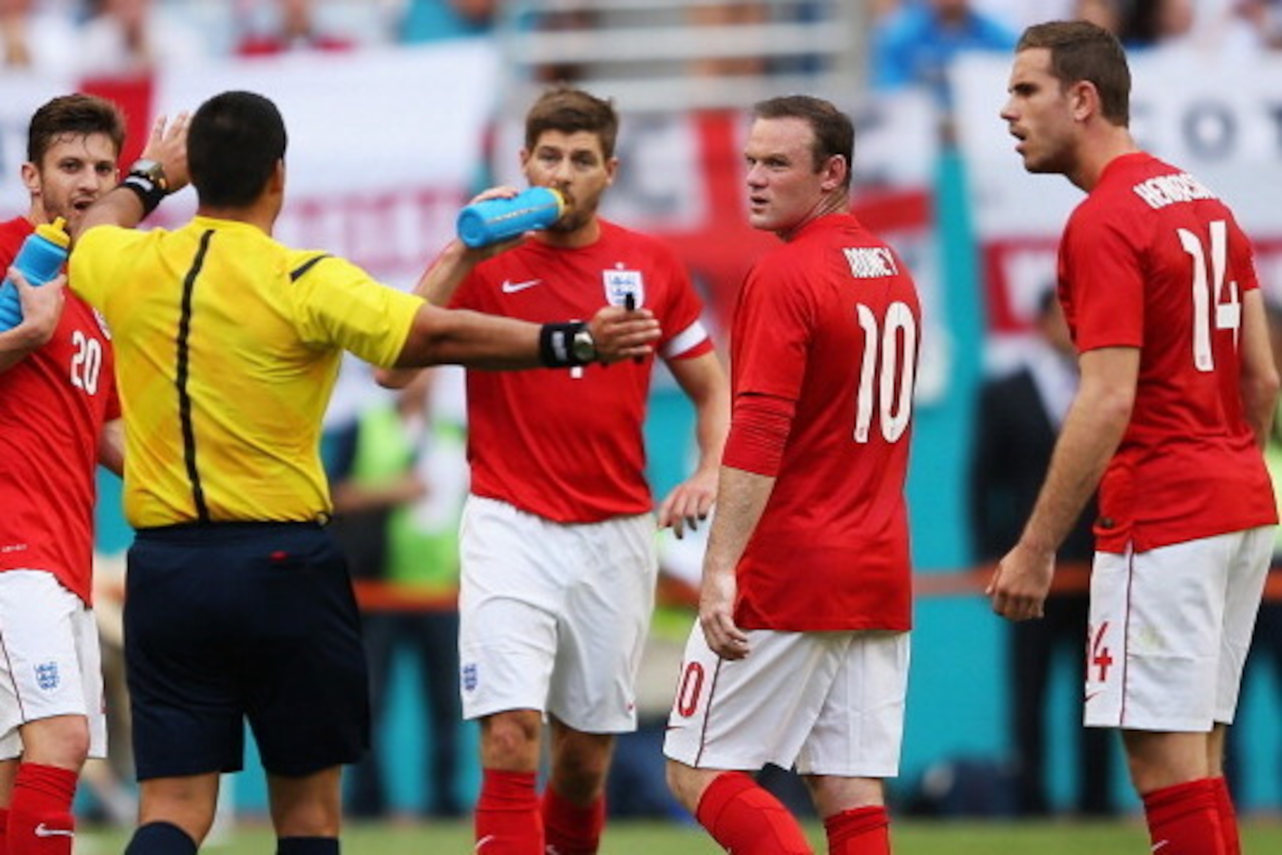 MIAMI GARDENS, FL - JUNE 07:  Referee Ricardo Salazar (2nd L) speaks to Adam Lallana (L), Steven Gerrard (C), Wayne Rooney (2nd R) and Jordan Henderson (R) as Salazar delays the match due to inclement weather in the first half during the International Fri