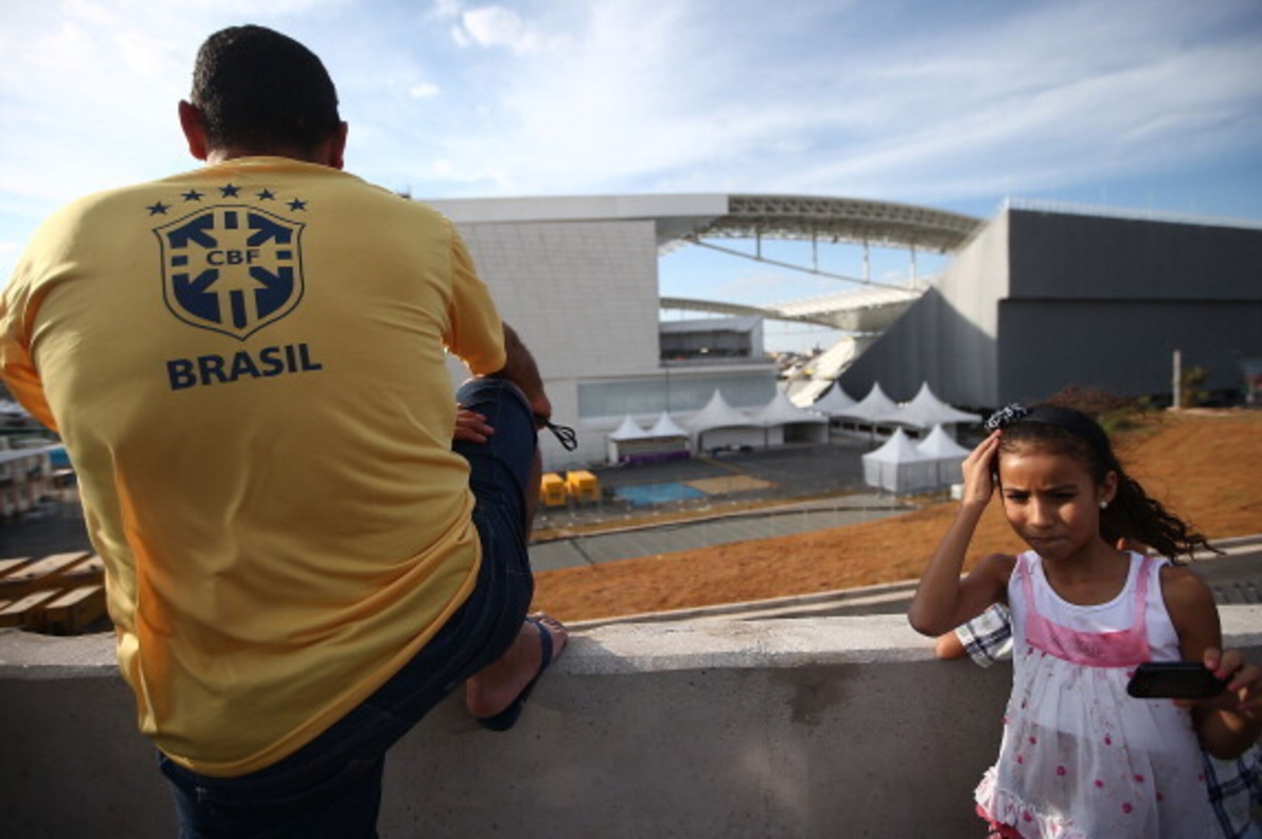 SAO PAULO, BRAZIL - JUNE 08:  Brazil fans gather outside Itaquerao stadium, also known as Arena de Sao Paulo and Arena Corinthians, on June 8, 2014 in Sao Paulo, Brazil. Hundreds of fans turned up at the stadium to take a peek on the final Sunday before t