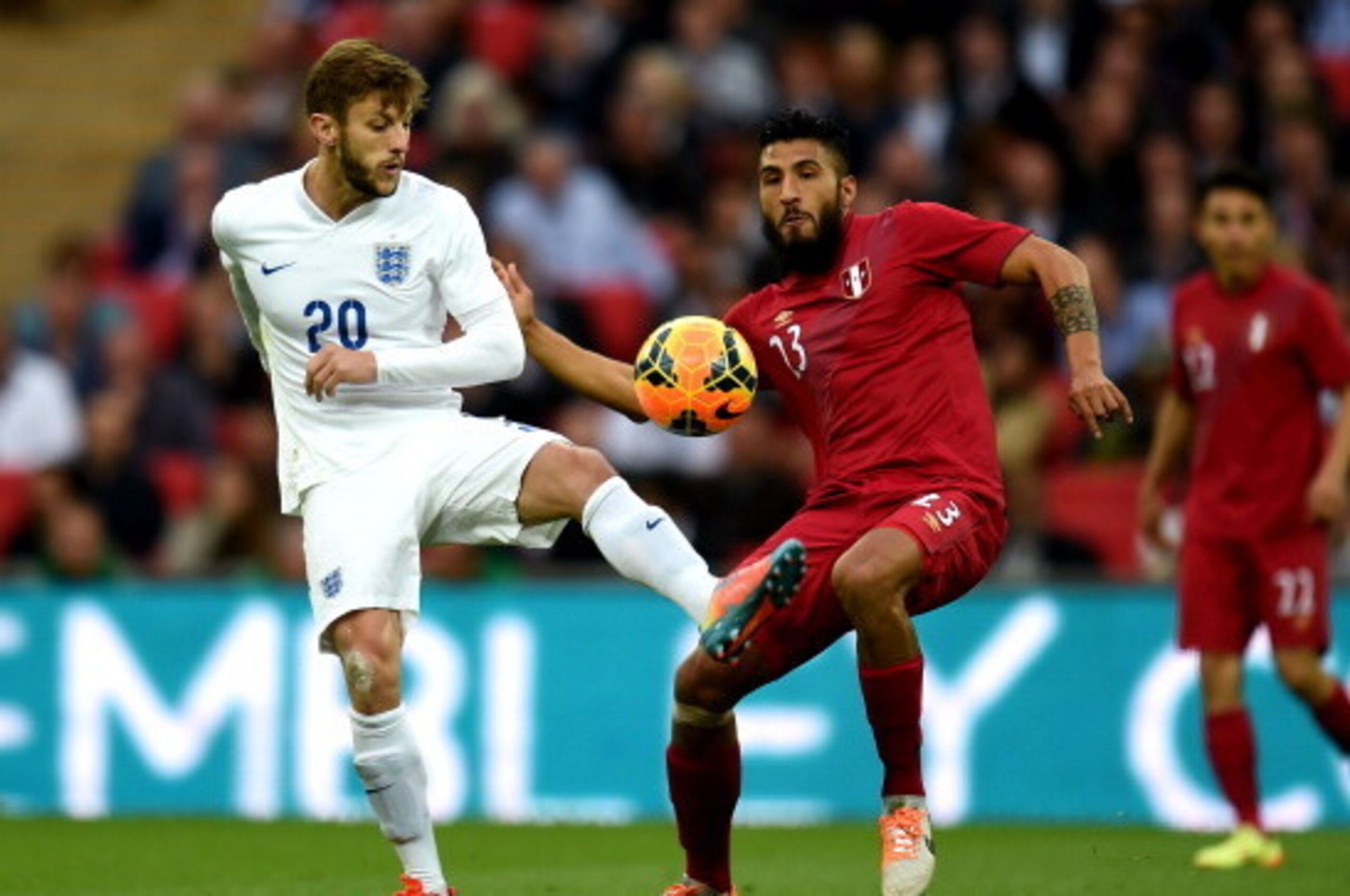LONDON, ENGLAND - MAY 30:  Adam Lallana of England and Mario Velarde of Peru compete for the ball during the international friendly match between England and Peru at Wembley Stadium on May 30, 2014 in London, England.  (Photo by Shaun Botterill/Getty Imag