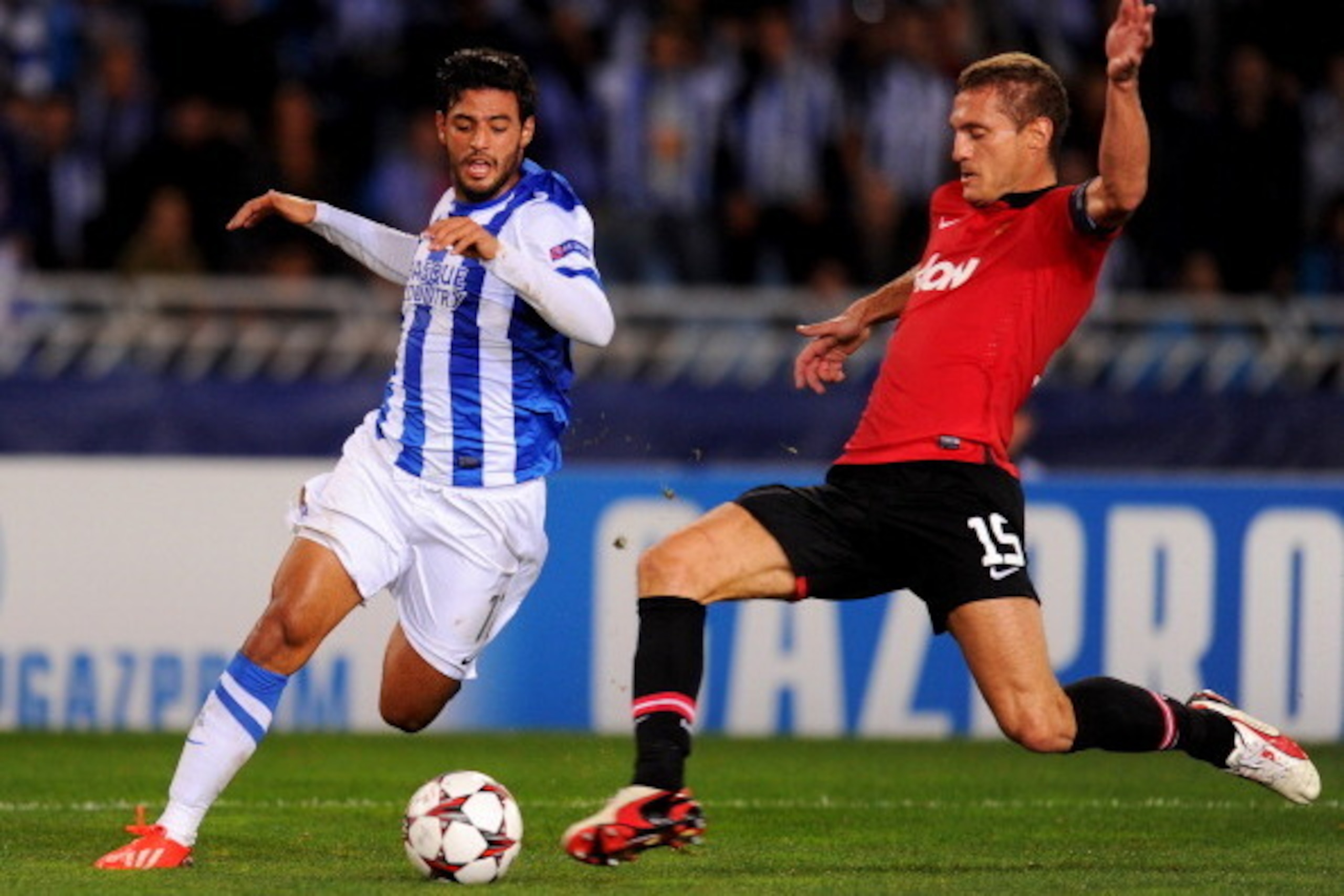 SAN SEBASTIAN, SPAIN - NOVEMBER 05:  Nemanja Vidic of Manchester United tackles Carlos Vela of Real Sociedad during the UEFA Champions League Group A match between Real Sociedad de Futbol and Manchester United at Estadio Anoeta on November 5, 2013 in San 