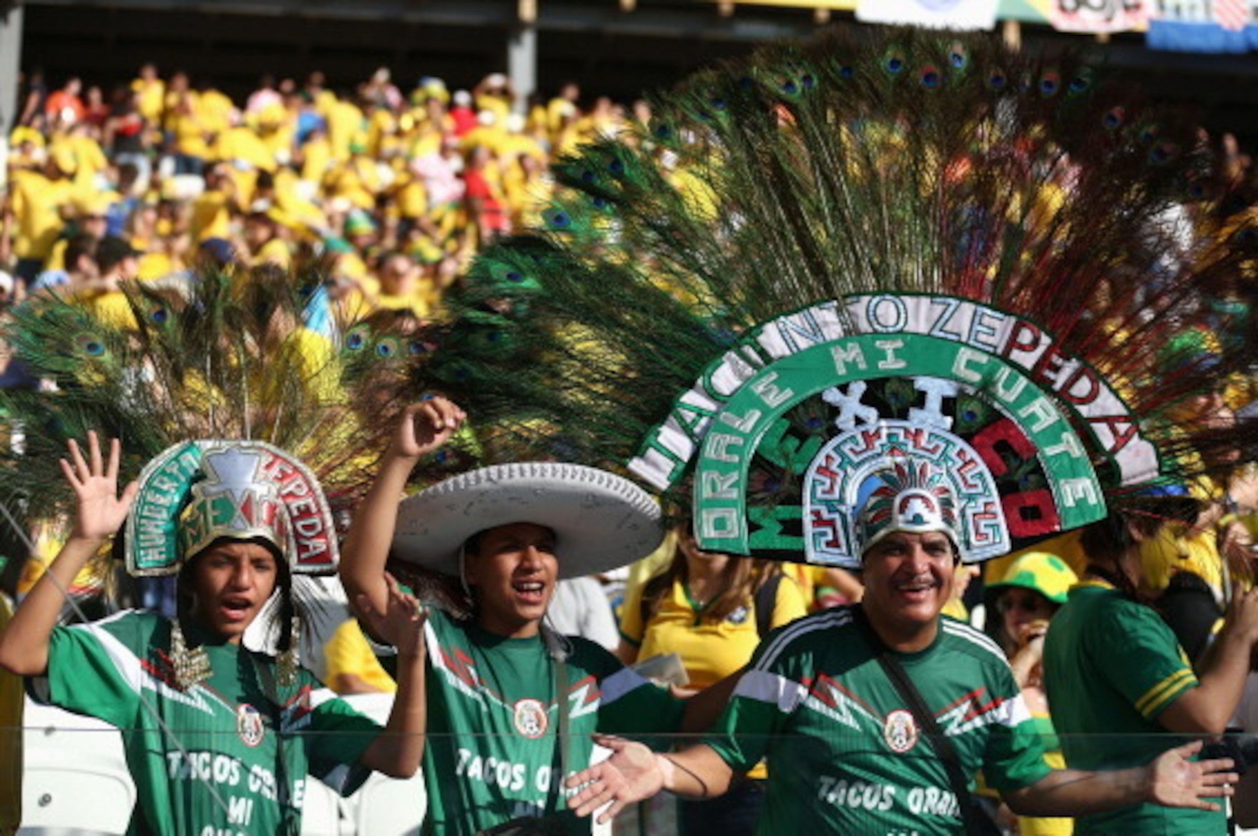 SAO PAULO, BRAZIL - JUNE 12:  Mexico fans cheer wearing large peacock feathered headdresses before the Opening Ceremony of the 2014 FIFA World Cup Brazil prior to the Group A match between Brazil and Croatia at Arena de Sao Paulo on June 12, 2014 in Sao P