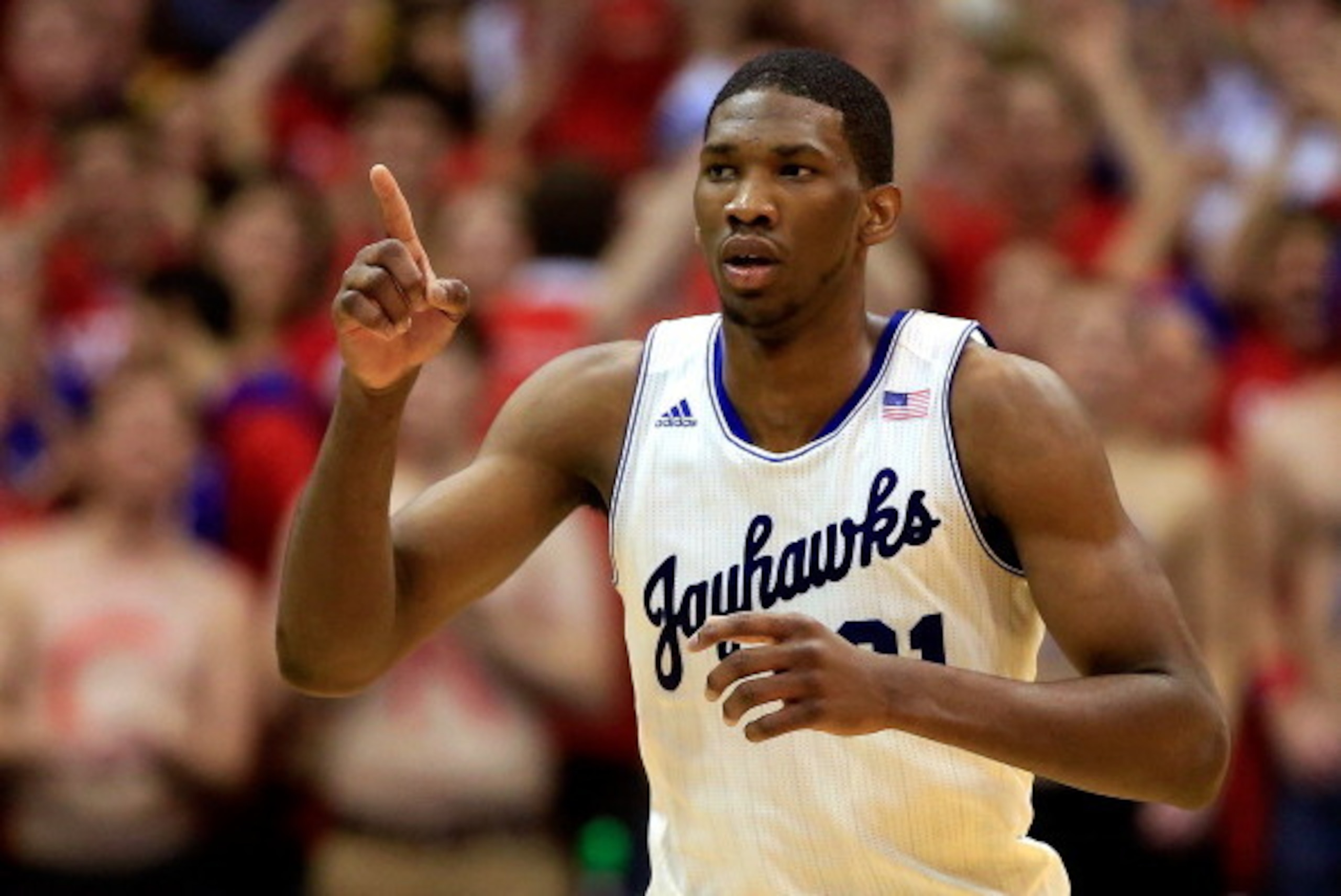 LAWRENCE, KS - JANUARY 18:  Joel Embiid #21 of the Kansas Jayhawks reacts after scoring during the game against the Oklahoma State Cowboys at Allen Fieldhouse on January 18, 2014 in Lawrence, Kansas.  (Photo by Jamie Squire/Getty Images)