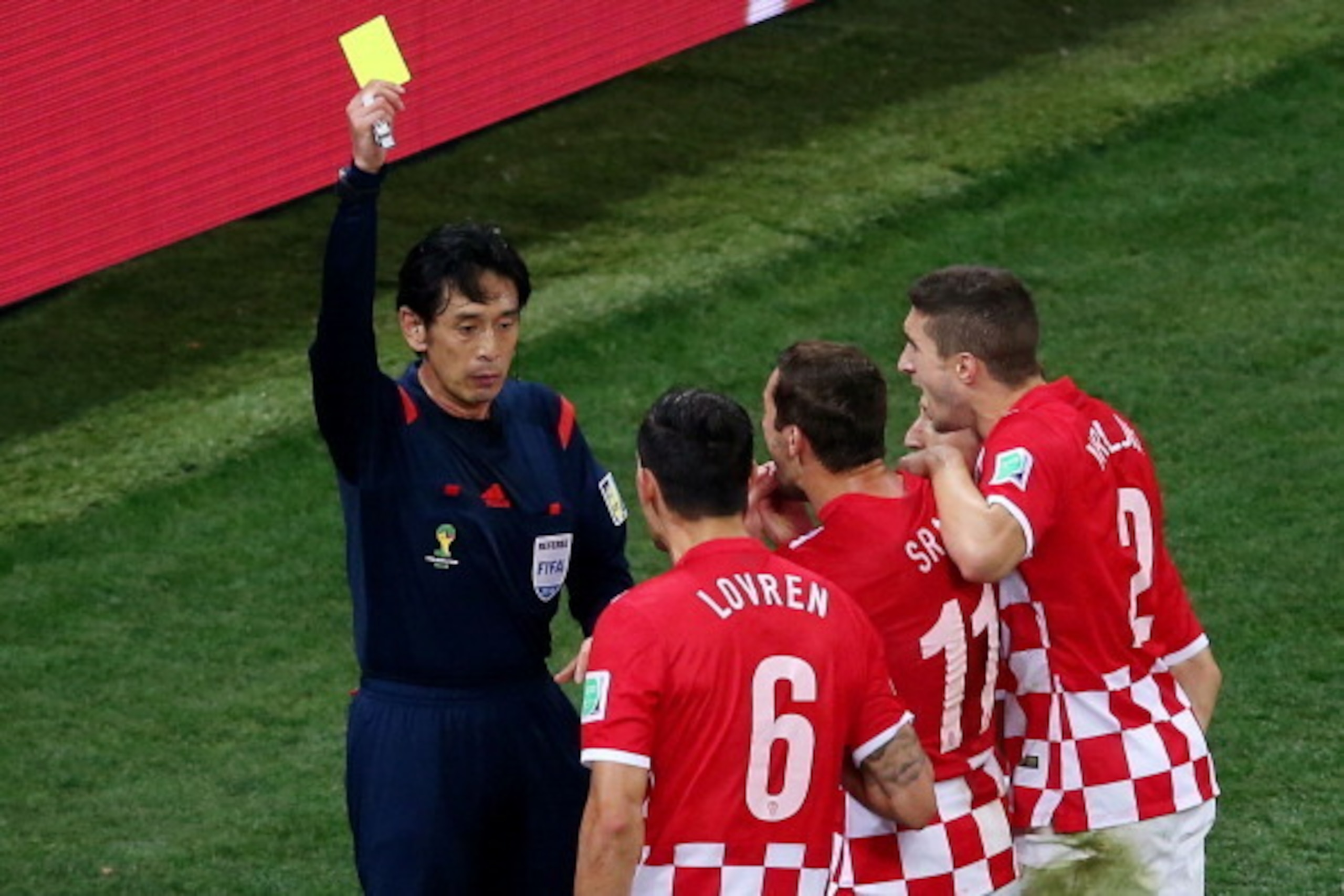 SAO PAULO, BRAZIL - JUNE 12:  Referee Yuichi Nishimura shows Dejan Lovren of Croatia (2nd L) a yellow card and awards a penalty kick during the 2014 FIFA World Cup Brazil Group A match between Brazil and Croatia at Arena de Sao Paulo on June 12, 2014 in S