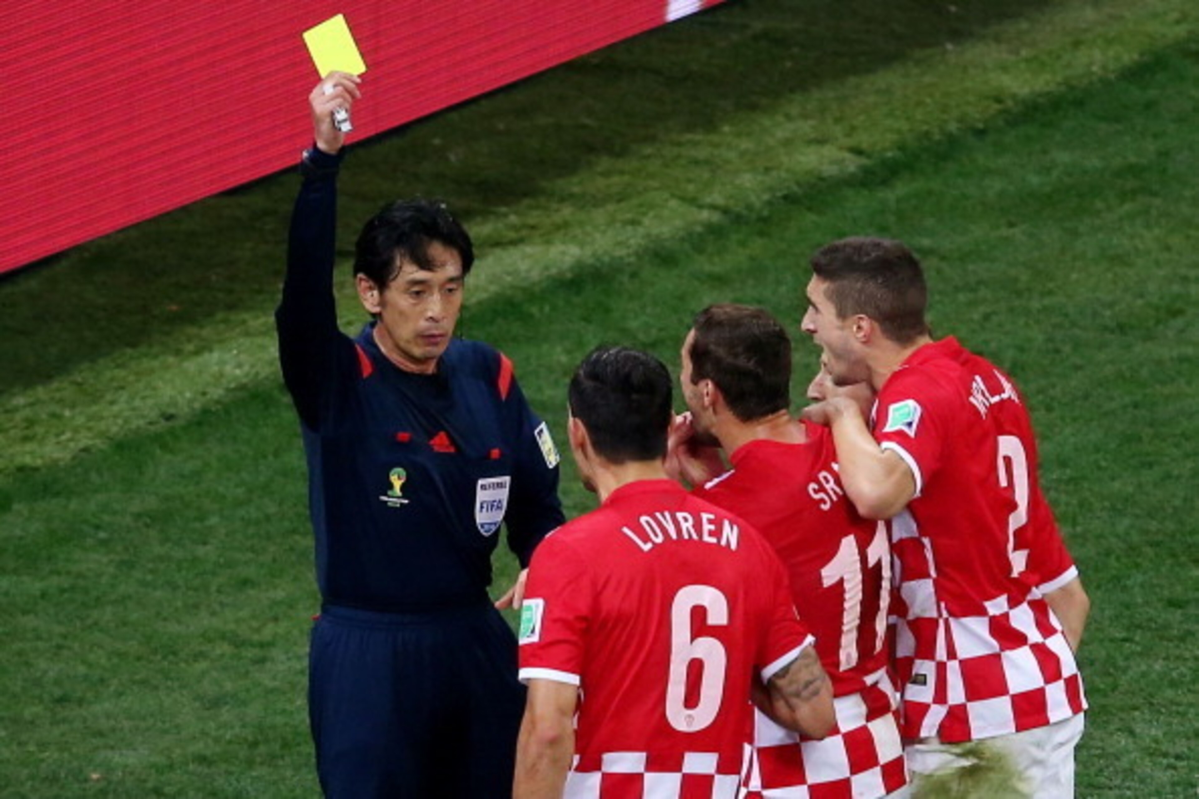 SAO PAULO, BRAZIL - JUNE 12:  Referee Yuichi Nishimura shows Dejan Lovren of Croatia (2nd L) a yellow card and awards a penalty kick during the 2014 FIFA World Cup Brazil Group A match between Brazil and Croatia at Arena de Sao Paulo on June 12, 2014 in S