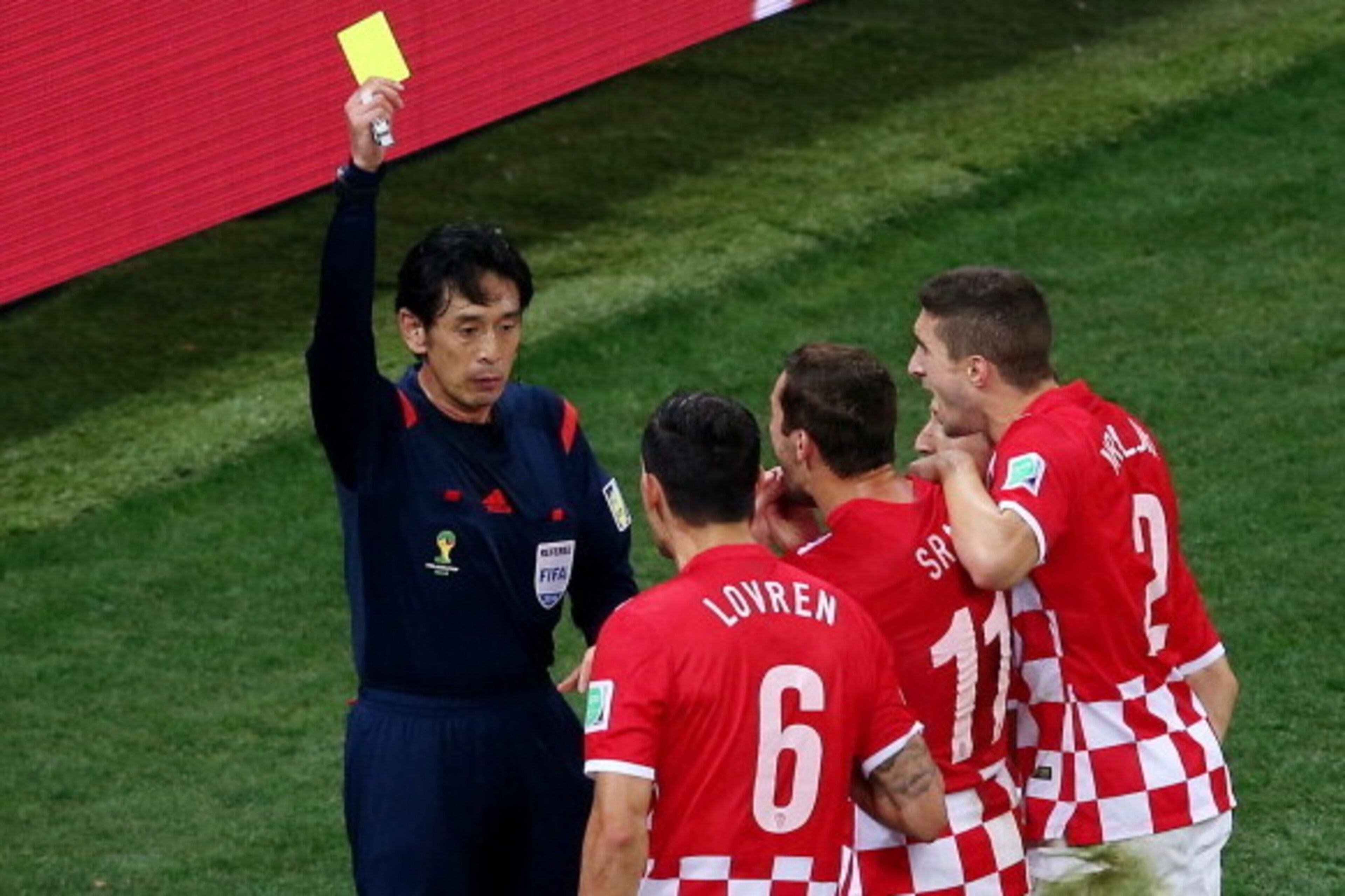 SAO PAULO, BRAZIL - JUNE 12:  Referee Yuichi Nishimura shows Dejan Lovren of Croatia (2nd L) a yellow card and awards a penalty kick during the 2014 FIFA World Cup Brazil Group A match between Brazil and Croatia at Arena de Sao Paulo on June 12, 2014 in S