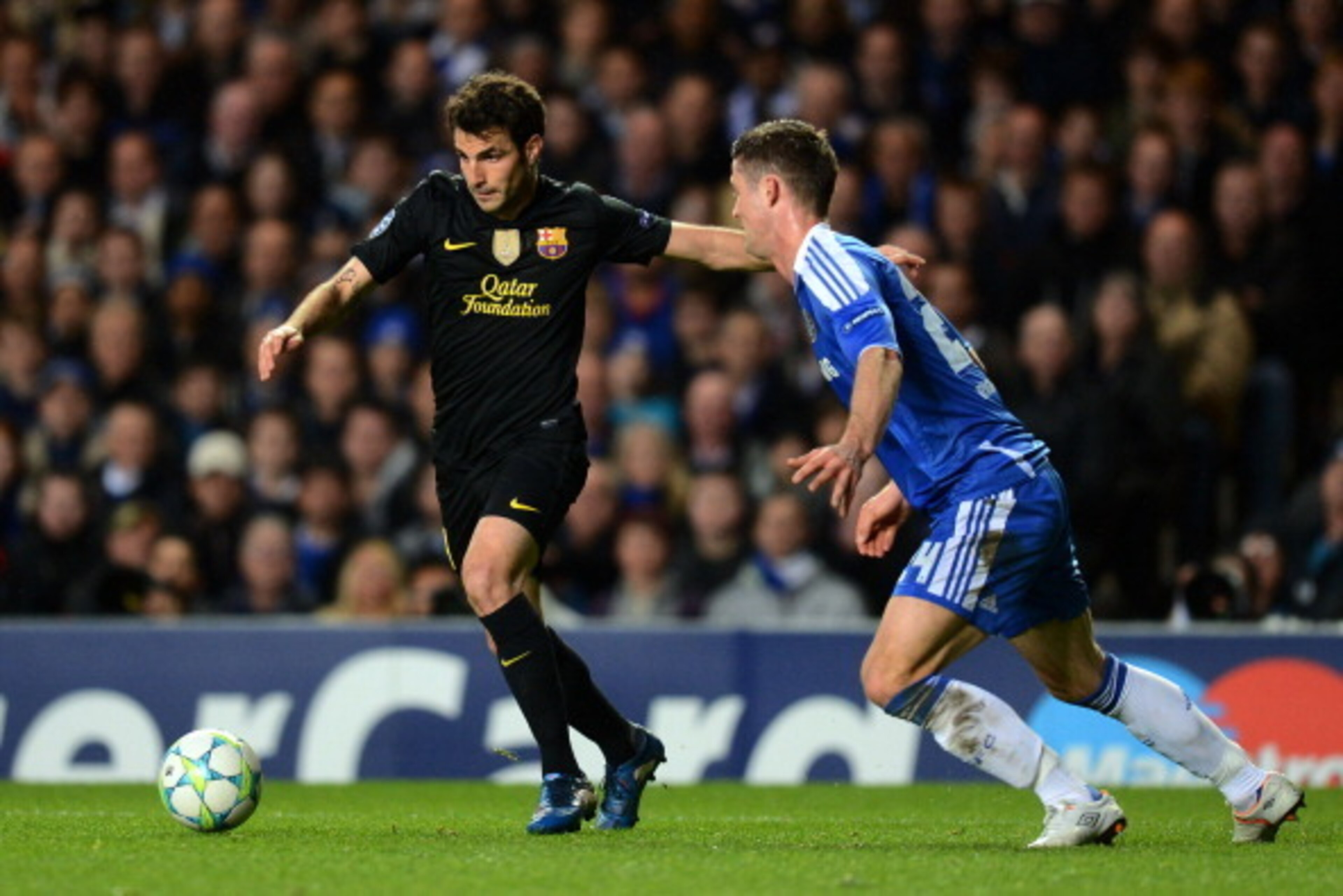 LONDON, ENGLAND - APRIL 18: Cesc Fabregas of Barcelona is closed down by Gary Cahill of Chelsea during the UEFA Champions League Semi Final first leg match between Chelsea and Barcelona at Stamford Bridge on April 18, 2012 in London, England.  (Photo by M
