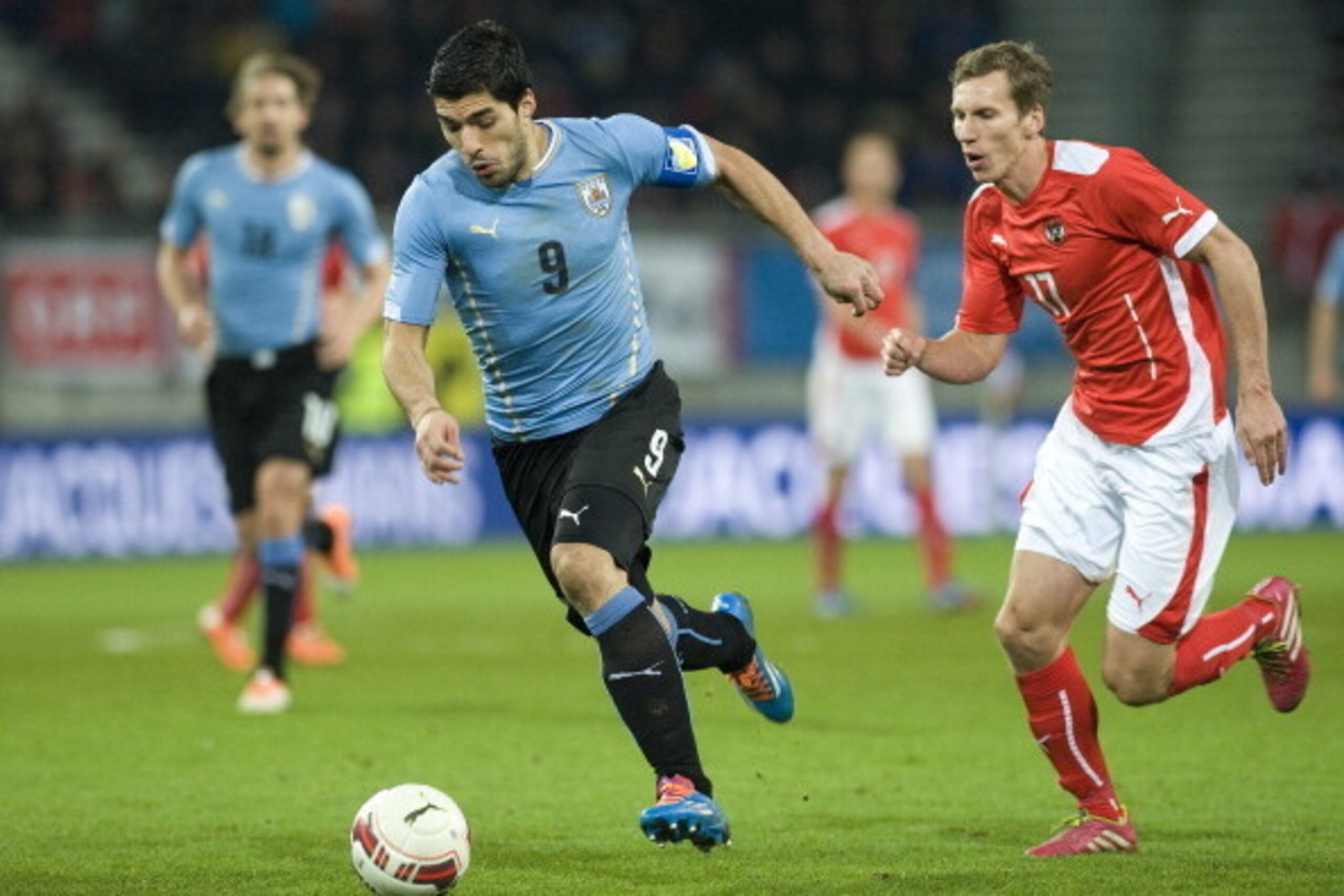 KLAGENFURT, AUSTRIA - MARCH 05:  Luis Suarez of Uruguay runs with the ball from Florian Klein of Austria during the international friendly match between Austria and Uruguay at Woerthersee stadium on March 5, 2014 in Klagenfurt, Austria.  (Photo by Winnie 