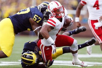 ANN ARBOR, MI - NOVEMBER 09:  Frank Clark #57 and Courtney Avery #11 of the Michigan Wolverines bring down Ameer Abdullah #8 of the Nebraska Cornhuskers in the first quarter at Michigan Stadium on November 9, 2013 in Ann Arbor, Michigan.  (Photo by Gregor