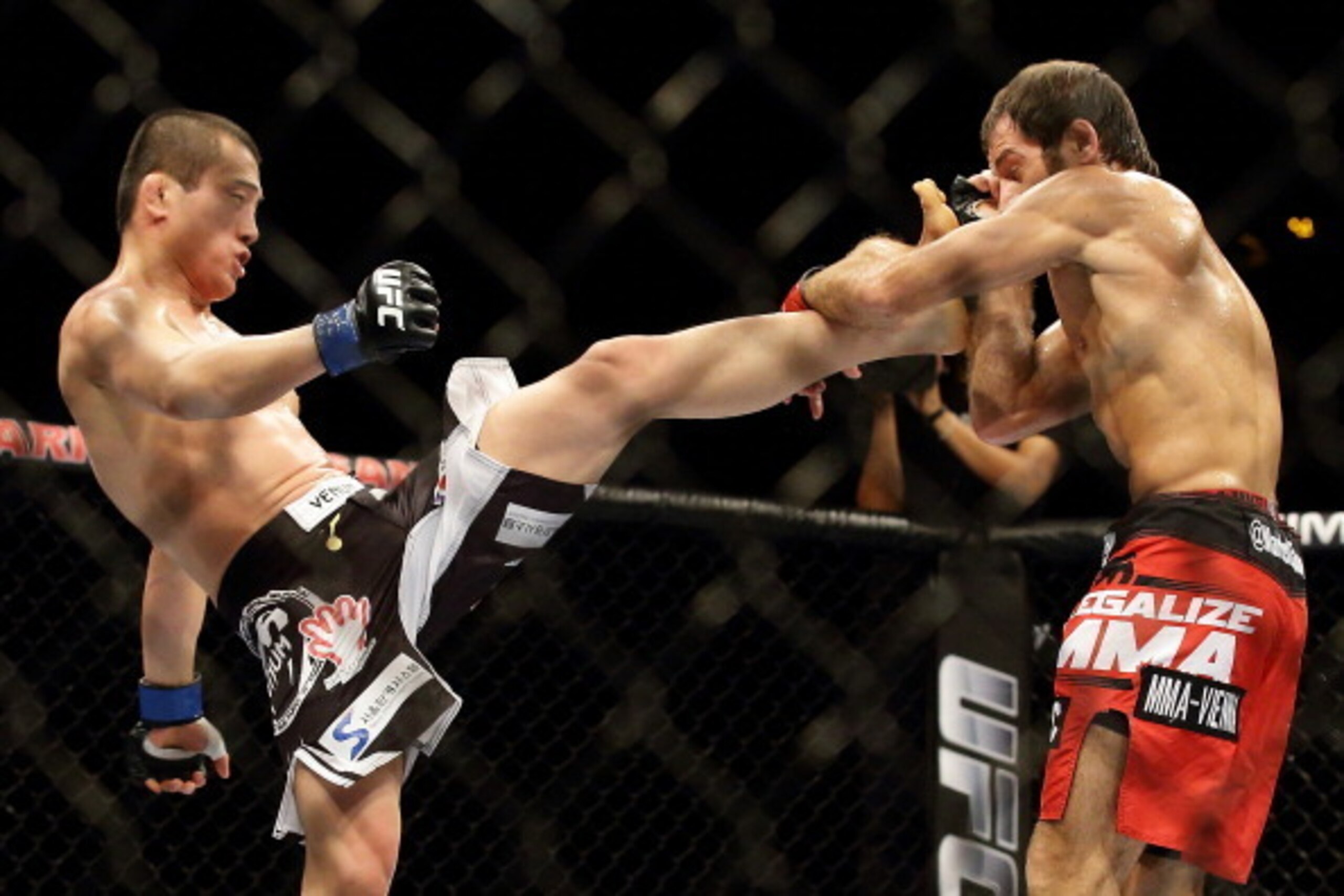 SINGAPORE - JANUARY 04:  Tae Hyun Bang (L) kicks Mairbek Taisumov during their UFC Fight Night Singapore lightweight bout at Marina Bay Sands on January 4, 2014 in Singapore.  (Photo by Suhaimi Abdullah/Getty Images)