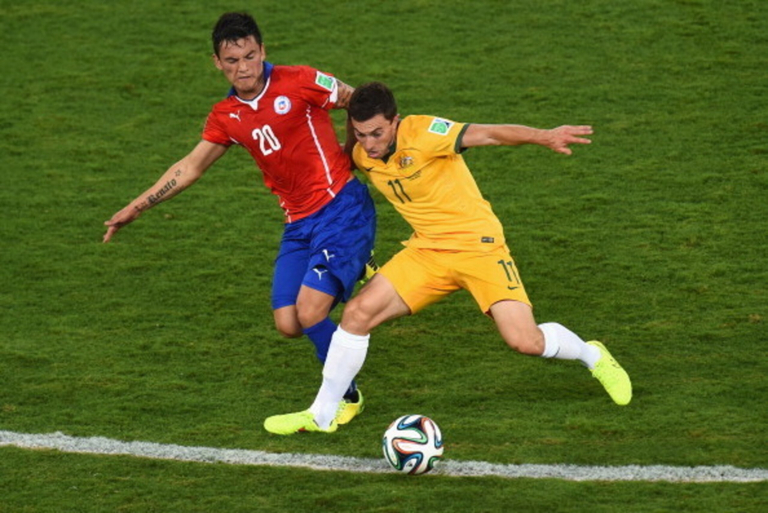CUIABA, BRAZIL - JUNE 13: Charles Aranguiz of Chile challenges Tommy Oar of Australia during the 2014 FIFA World Cup Brazil Group B match between Chile and Australia at Arena Pantanal on June 13, 2014 in Cuiaba, Brazil.  (Photo by Stu Forster/Getty Images