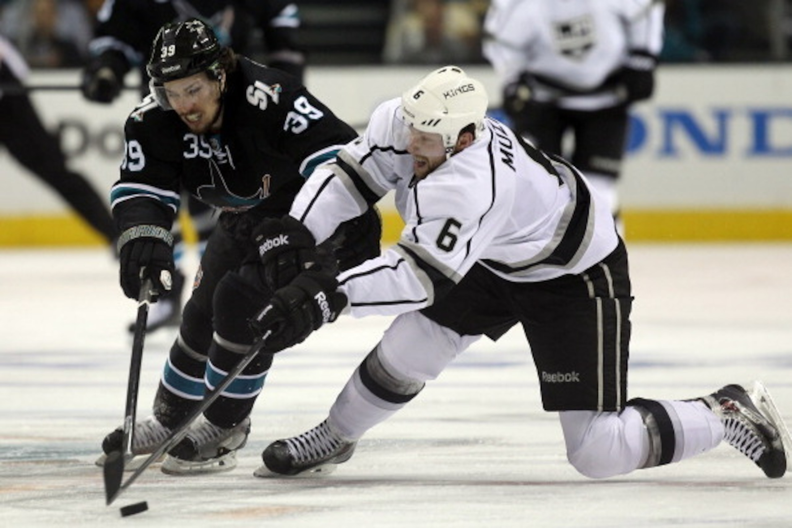 SAN JOSE, CA - APRIL 30:  Logan Couture #39 of the San Jose Sharks and Jake Muzzin #6 of the Los Angeles Kings go for the puck in Game Seven of the First Round of the 2014 NHL Stanley Cup Playoffs at SAP Center on April 30, 2014 in San Jose, California.  