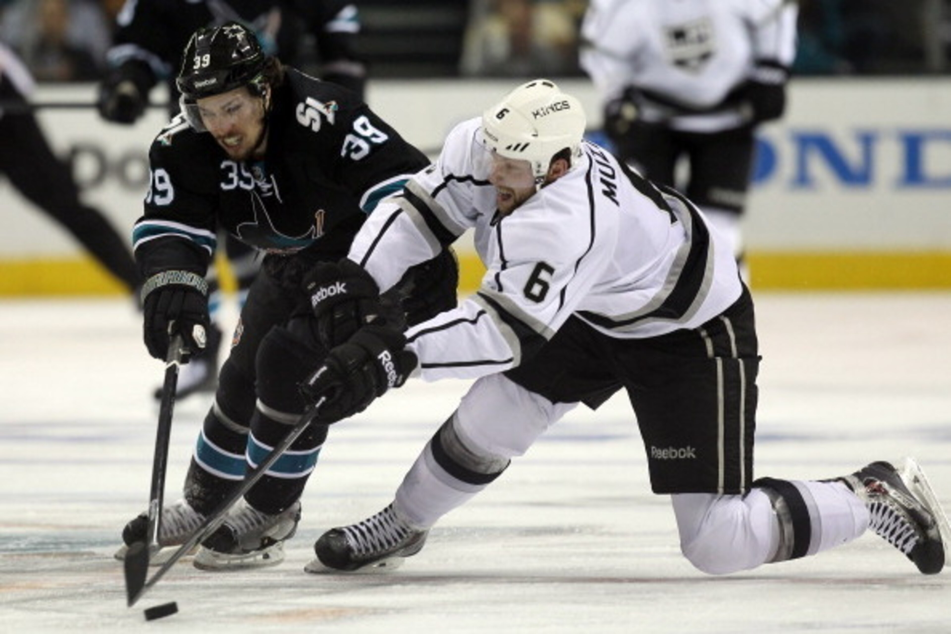 SAN JOSE, CA - APRIL 30:  Logan Couture #39 of the San Jose Sharks and Jake Muzzin #6 of the Los Angeles Kings go for the puck in Game Seven of the First Round of the 2014 NHL Stanley Cup Playoffs at SAP Center on April 30, 2014 in San Jose, California.  
