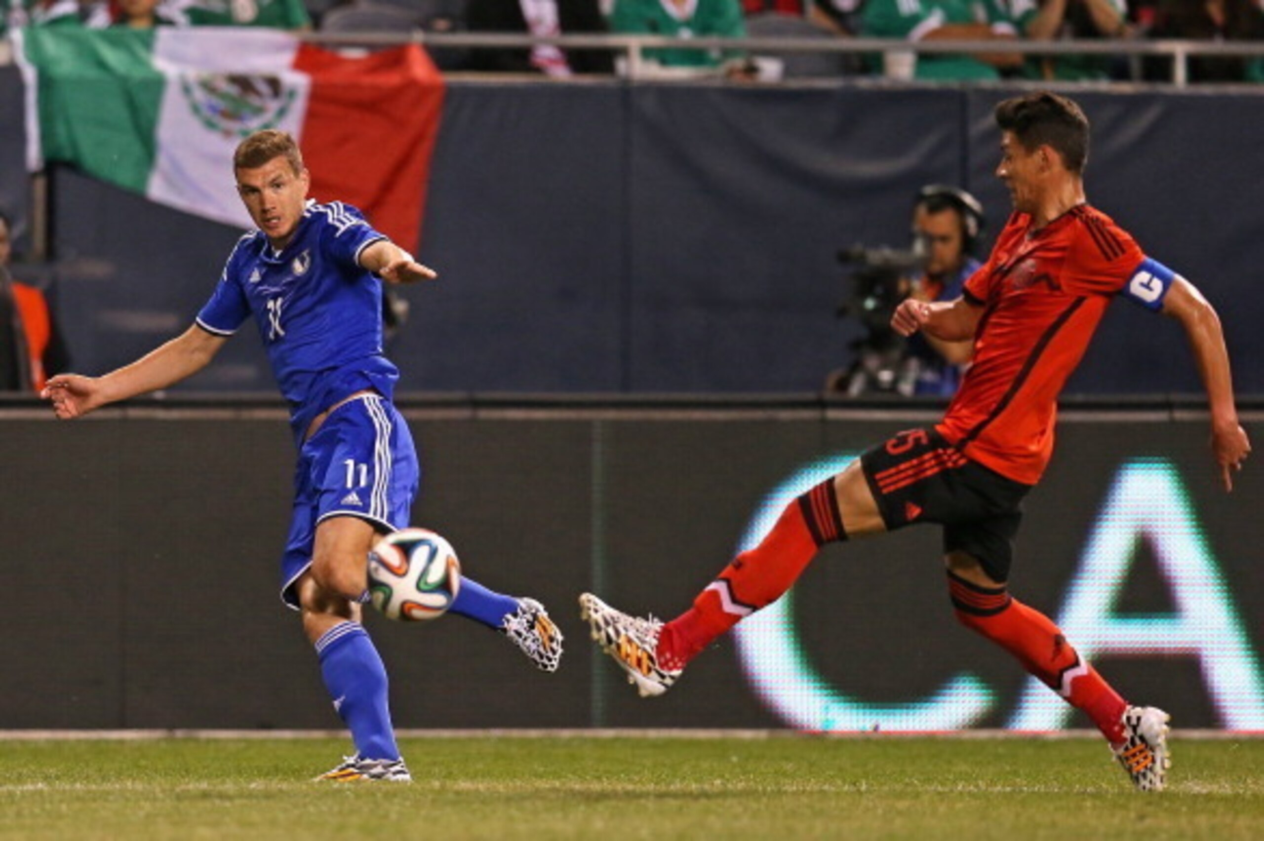CHICAGO, IL - JUNE 03: Edin Dzeko #11 of Bosnia & Herzegovina passes under pressure from Hector Moreno #15 of Mexico during an international friendly match at Soldier Field on June 3, 2014 in Chicago, Illinois. Bosnia & Herzegovina defeated Mexico 1-0. (P