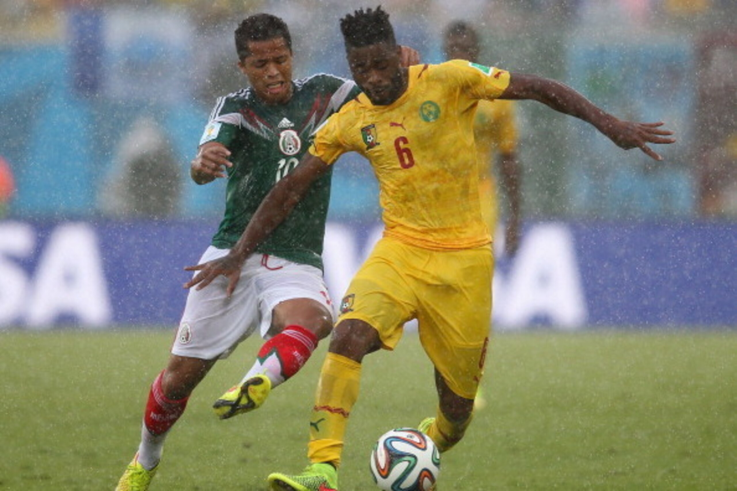 NATAL, BRAZIL - JUNE 13: Alex Song of Cameroon controls the ball as Giovani dos Santos of Mexico challenges during the 2014 FIFA World Cup Brazil Group A match between Mexico and Cameroon at Estadio das Dunas on June 13, 2014 in Natal, Brazil. (Photo by NATAL, BRAZIL - JUNE 13: Alex Song of Cameroon controls the ball as Giovani dos Santos of Mexico challenges during the 2014 FIFA World Cup Brazil Group A match between Mexico and Cameroon at Estadio das Dunas on June 13, 2014 in Natal, Brazil. (Photo by