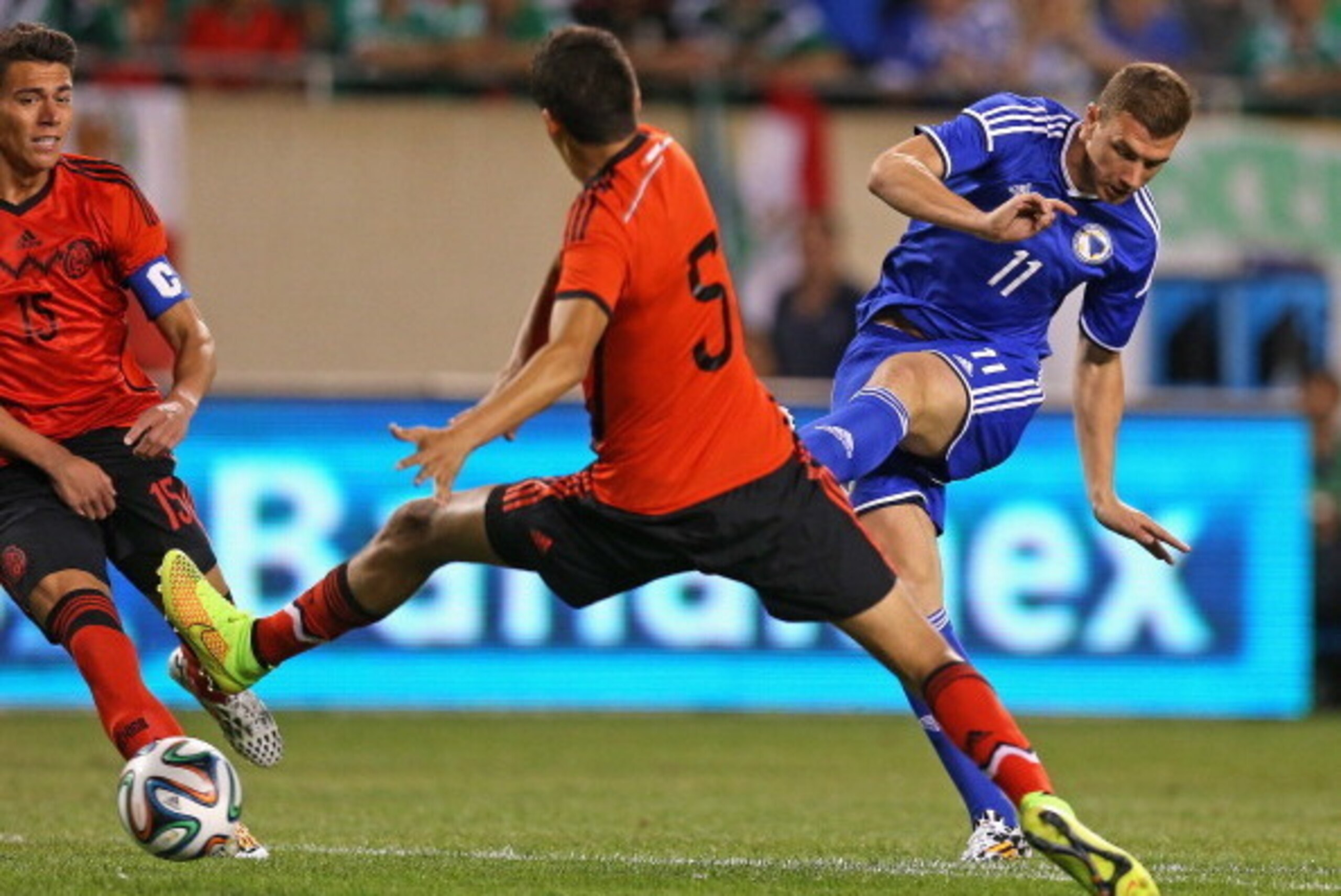 CHICAGO, IL - JUNE 03: Edin Dzeko #11 of Bosnia & Herzegovina shoots the ball between Hector Moreno #15 and Diego Reyes #5 of Mexico during an international friendly match at Soldier Field on June 3, 2014 in Chicago, Illinois. (Photo by Jonathan Daniel/Ge