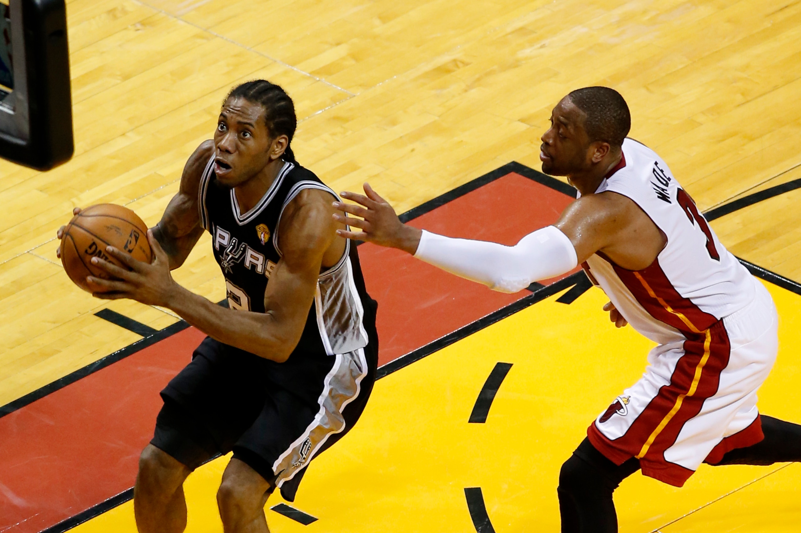 Jun 12, 2014; Miami, FL, USA; San Antonio Spurs forward Kawhi Leonard (2) shoots ahead of Miami Heat guard Dwyane Wade (3) during the fourth quarter of game four of the 2014 NBA Finals at American Airlines Arena. San Antonio defeated Miami 86-107. Mandato
