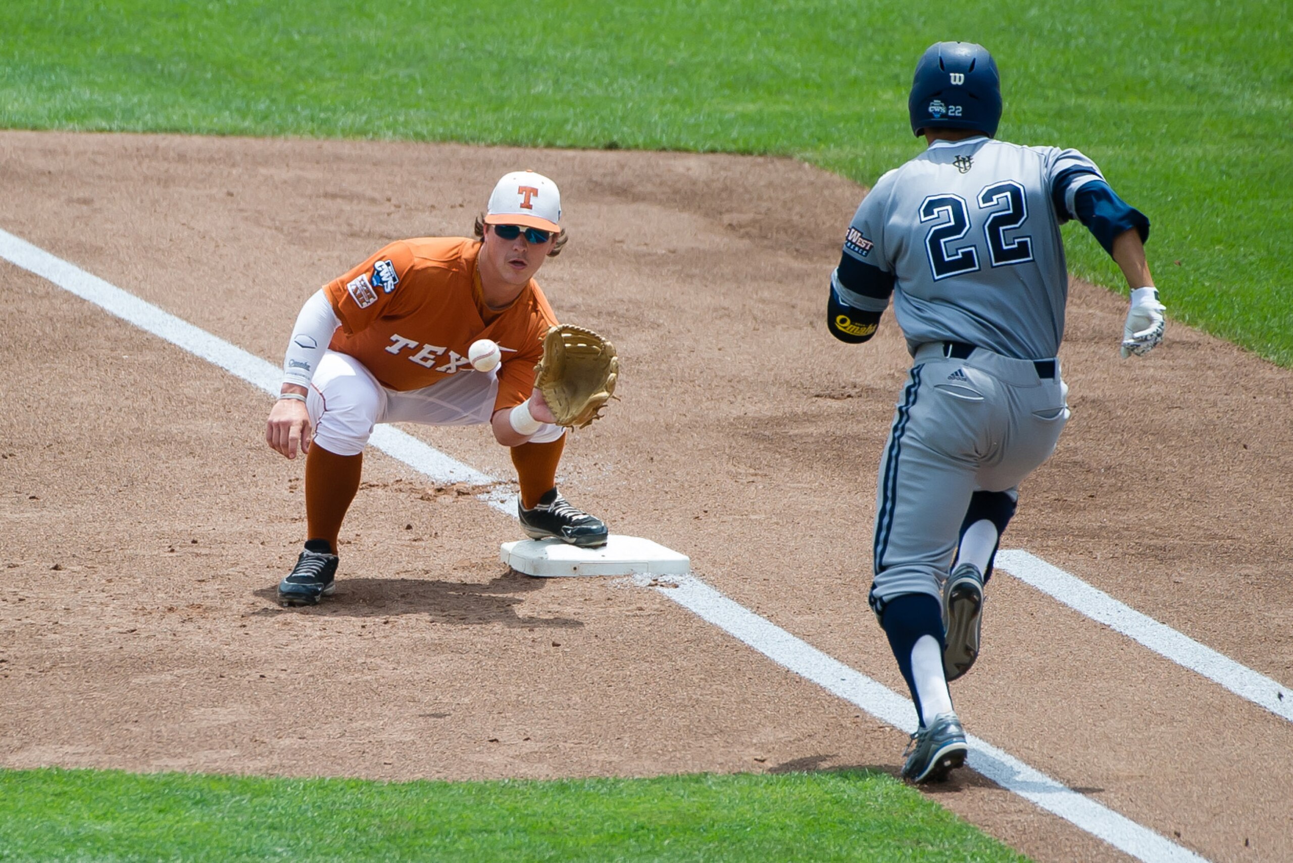 Jun 14, 2014; Omaha, NE, USA; UC Irvine Anteaters infielder Chris Rabago (22) is out at first against Texas Longhorns infielder Kacy Clemens (42) during game one of the 2014 College World Series at TD Ameritrade Park Omaha. Mandatory Credit: Steven Bransc Jun 14, 2014; Omaha, NE, USA; UC Irvine Anteaters infielder Chris Rabago (22) is out at first against Texas Longhorns infielder Kacy Clemens (42) during game one of the 2014 College World Series at TD Ameritrade Park Omaha. Mandatory Credit: Steven Bransc