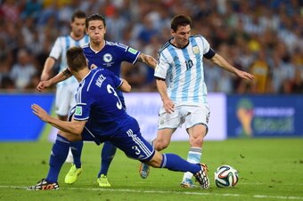 RIO DE JANEIRO, BRAZIL - JUNE 15:  Lionel Messi of Argentina controls the ball on his way to scoring his team's second goal against Ermin Bicakcic (L) and Muhamed Besic of Bosnia and Herzegovina during the 2014 FIFA World Cup Brazil Group F match between 