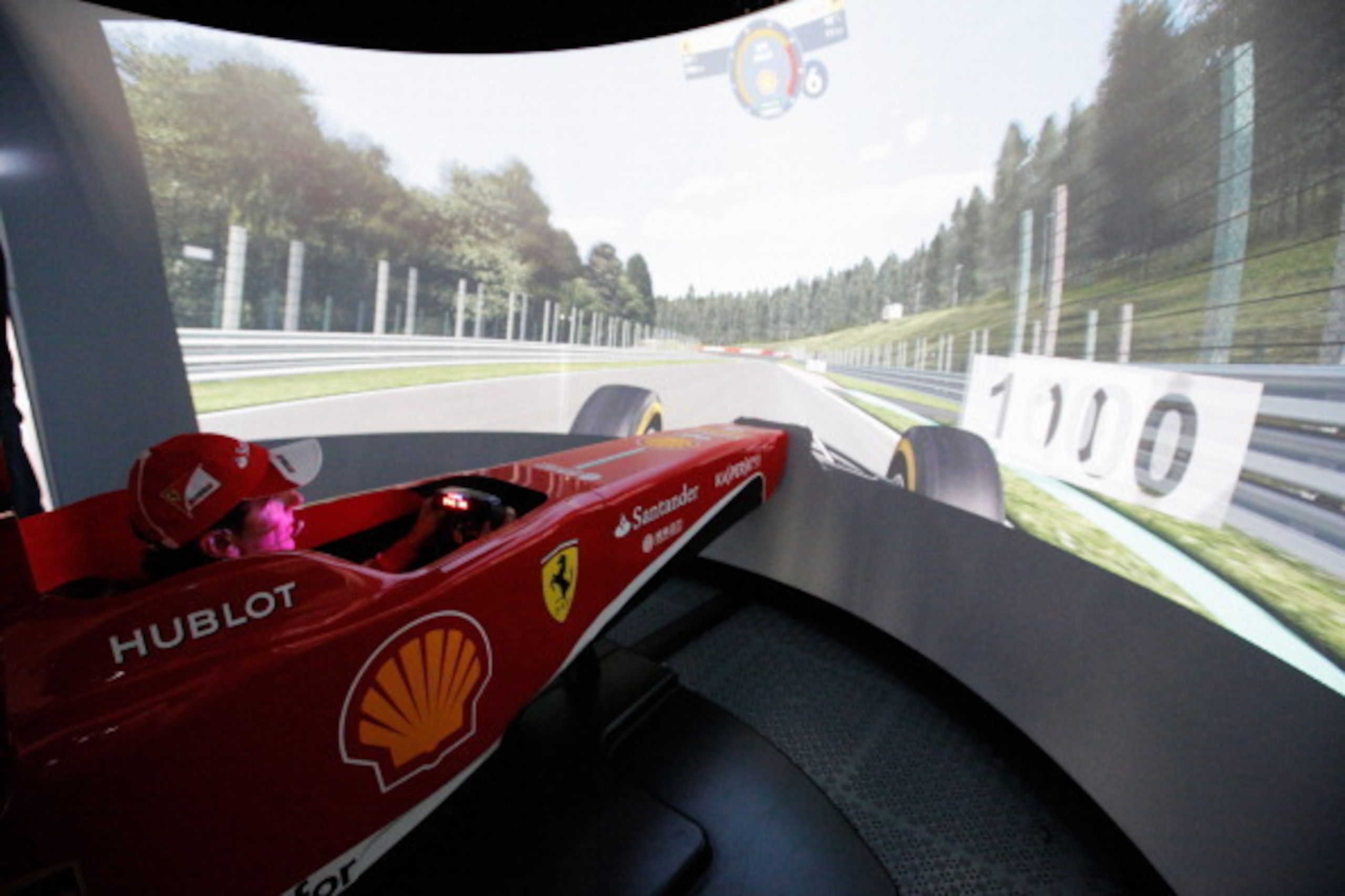 SPA, BELGIUM - AUGUST 23:  Pedro De La Rosa of Spain and Ferrari explains the workings of the Shell Professional Simulator to guests in the Shell VIP Suite following during practice for the Belgian Grand Prix at Circuit de Spa-Francorchamps on August 23, 