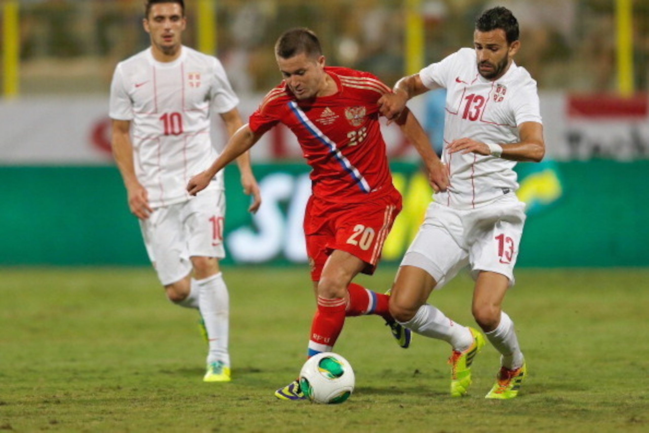 DUBAI, UNITED ARAB EMIRATES - NOVEMBER 15:  Victor Fayzulin (C) of Russia compete for the ball with Ivan Radovanovic (R) of Serbia during the International Football match between Serbia and Russia at the Zabeel Stauduim on November 15, 2013 in Dubai, Unit
